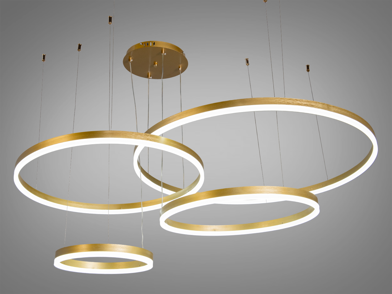 Світильник з трьома підвісними кільцями бронзового кольору, що створює м′яке освітлення. Підходить для вітальні або спальні.