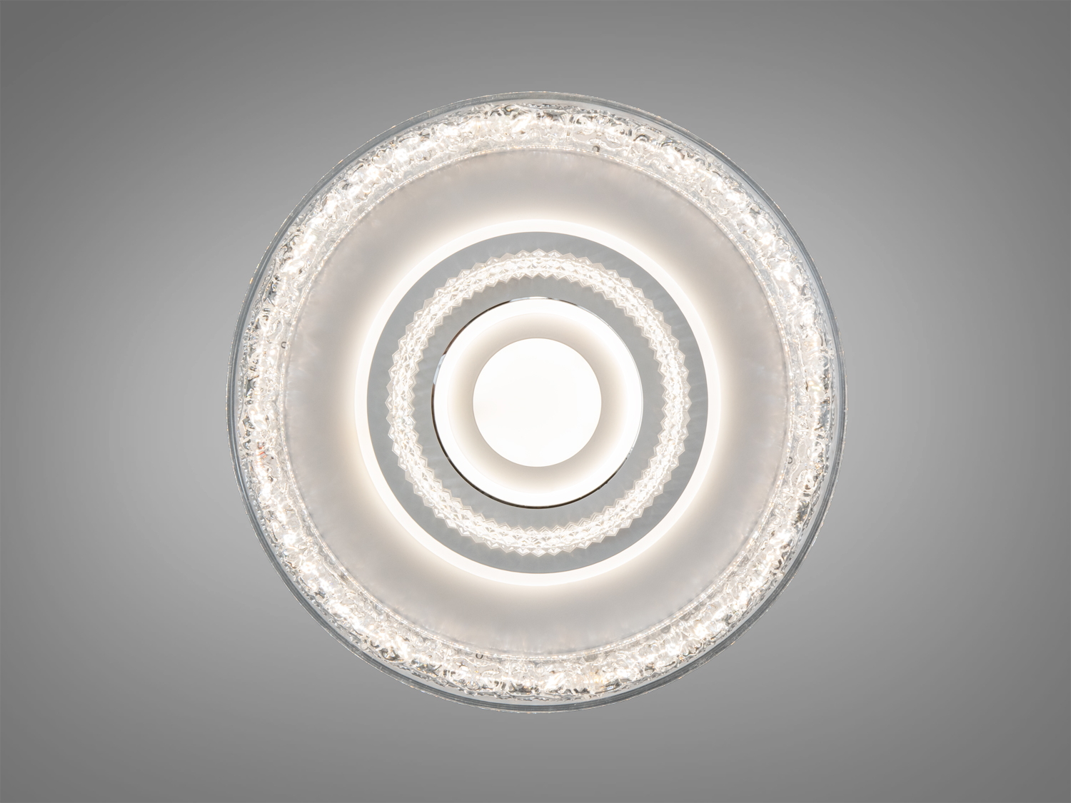 Стельова люстра з круглим дизайном, оснащена кришталевими кільцями. Випромінює м′яке світло, підходить для вітальні.