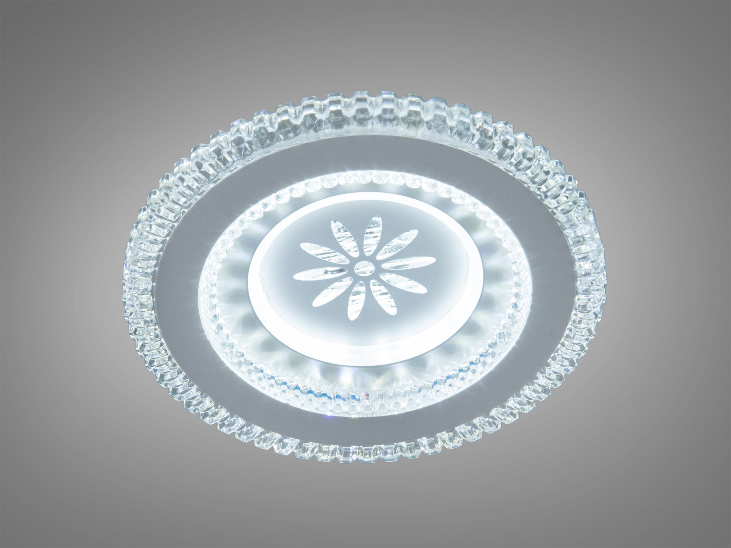 Круглий світильник з прозорого скла, що випромінює холодне біле світло, з квітковим візерунком у центрі, підходить для сучасних інтер′єрів.