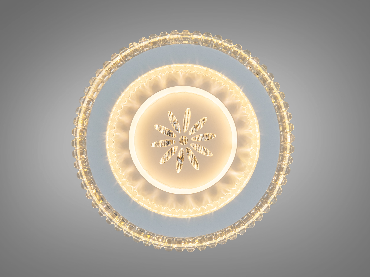 Світильник з теплим жовтим світлом, має круглу форму та декоративний квітковий візерунок, ідеальний для затишних приміщень.