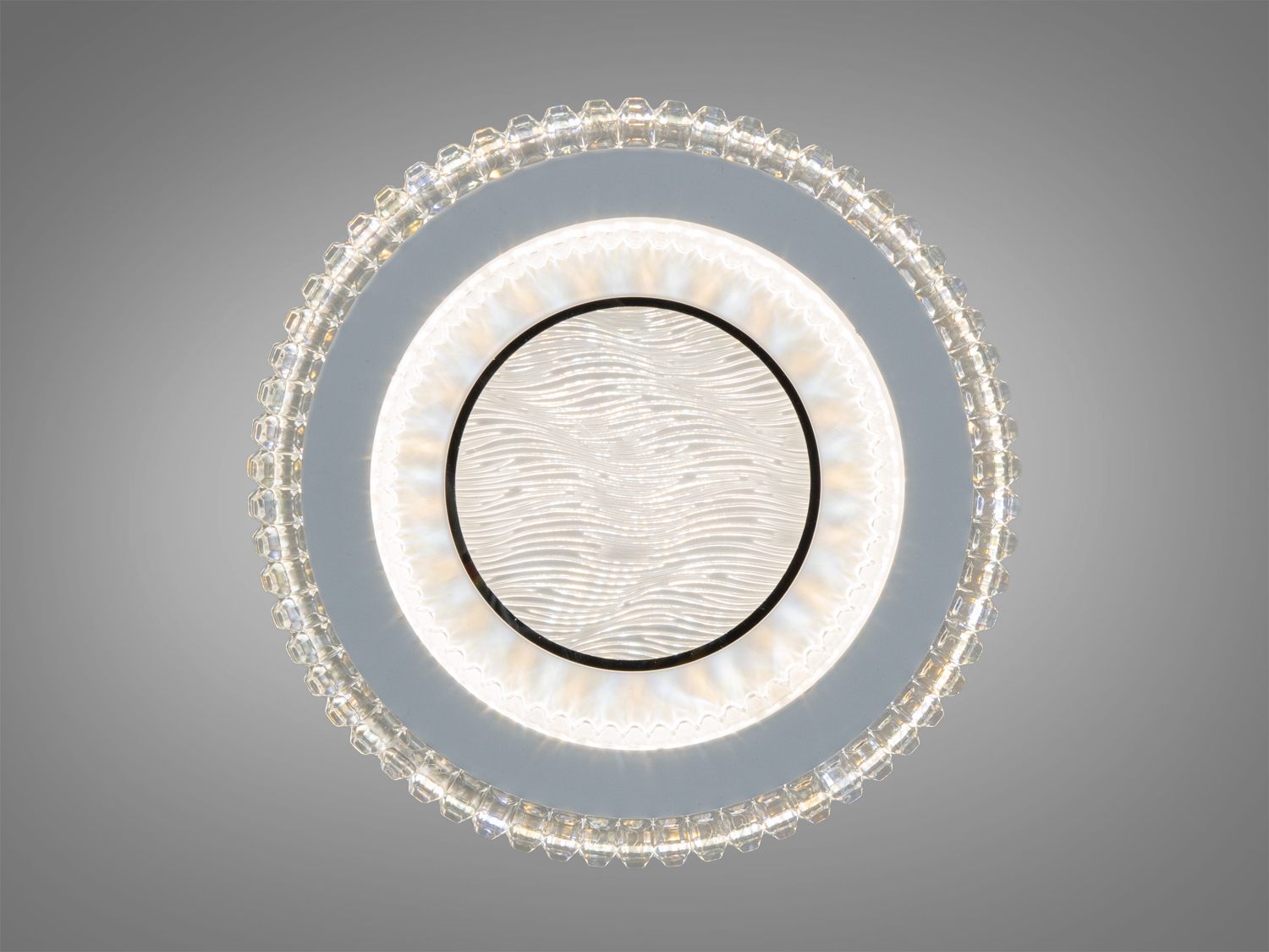 Вид зверху на круглу лампу з хвилястим візерунком у центрі. Акрилове обрамлення додає елегантності. Ідеальна для вітальні.