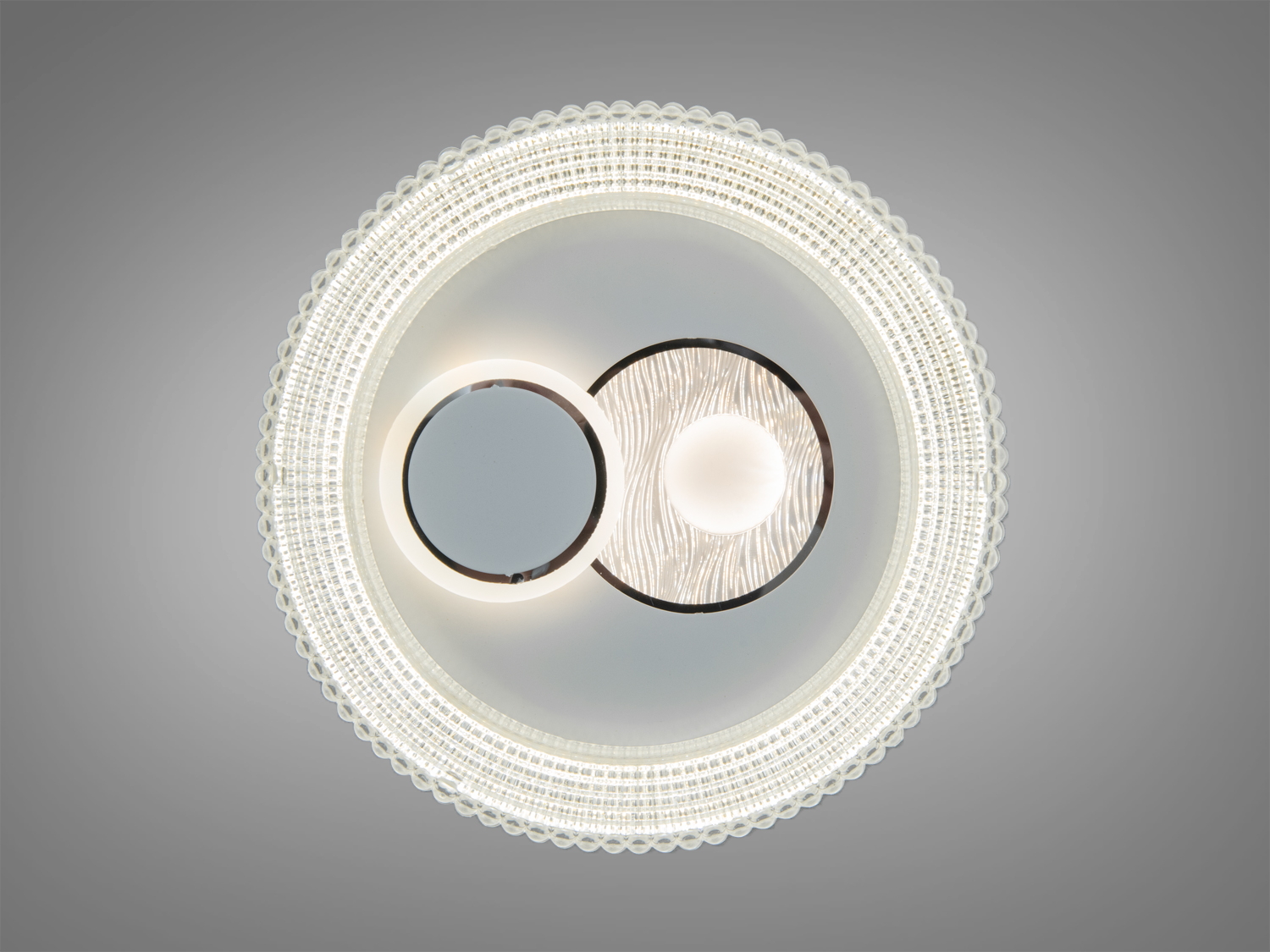 Стельова лампа з подвійним круглим дизайном, центральний елемент з хвилястим візерунком, що створює м′яке освітлення.