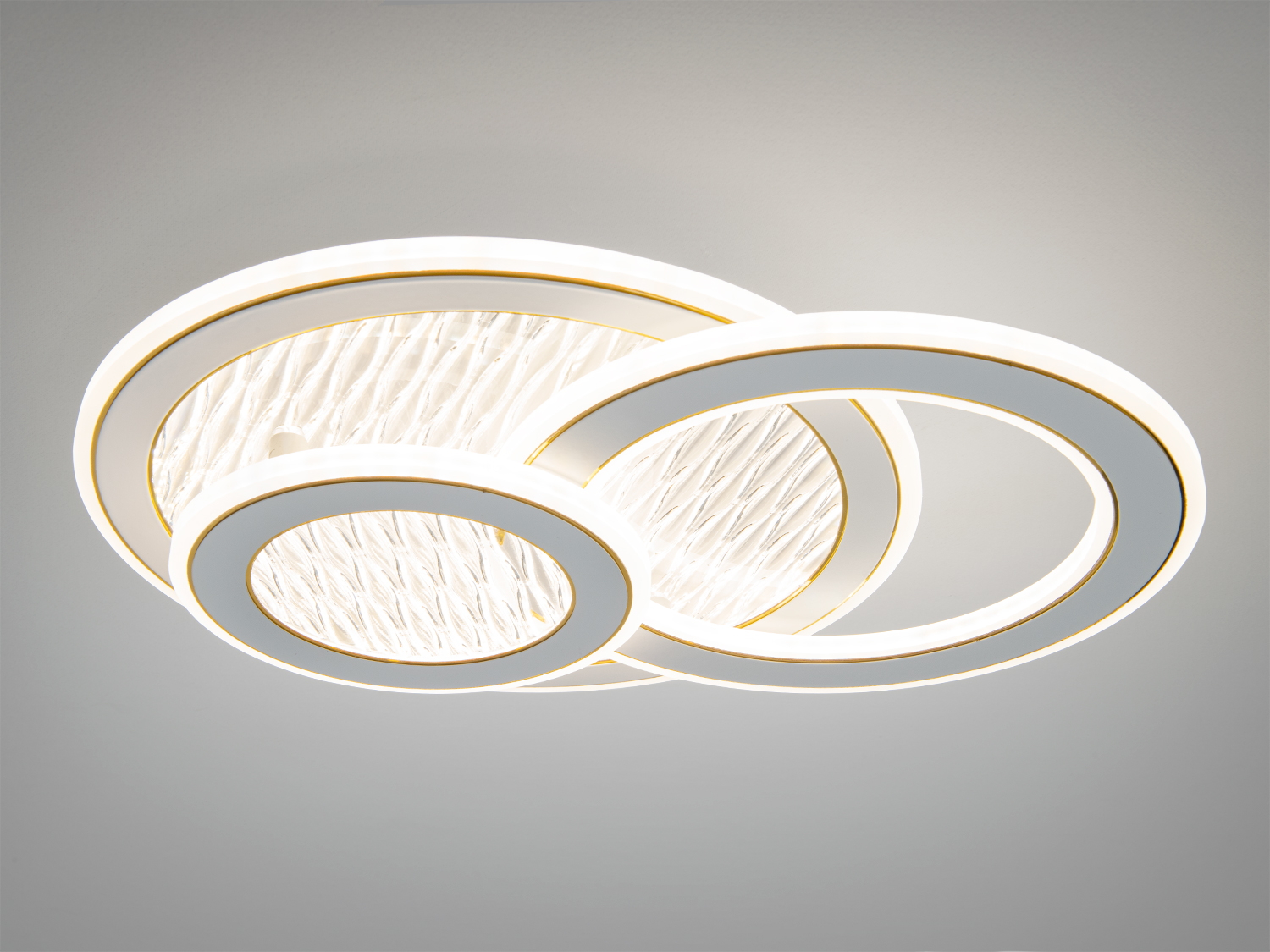 Підвісний світильник з трьома кільцями, що перекриваються, з золотими деталями. Ідеально підходить для стильного освітлення.