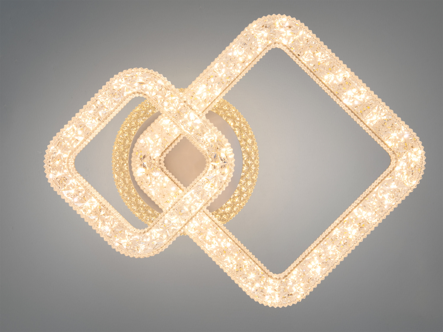 Світильник з теплим жовтим світлом, виконаний у формі двох квадратів, що перетинаються, підходить для затишного освітлення.