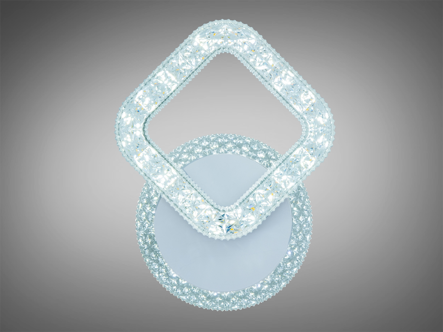 Настінний світильник з кристалічним оздобленням у формі ромба, що випромінює яскраве біле світло.