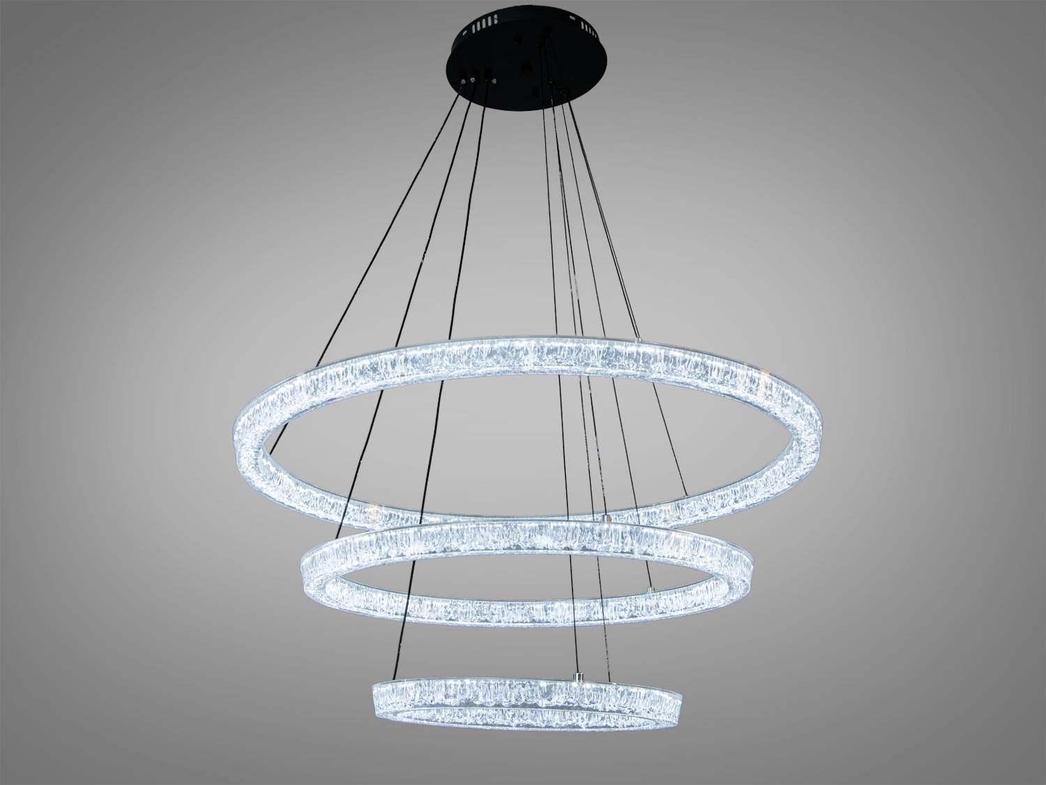 Світильник з трьома акриловими кільцями, що випромінюють холодне біле світло. Підвісна конструкція на чорному кріпленні, підходить для офісних приміщень.