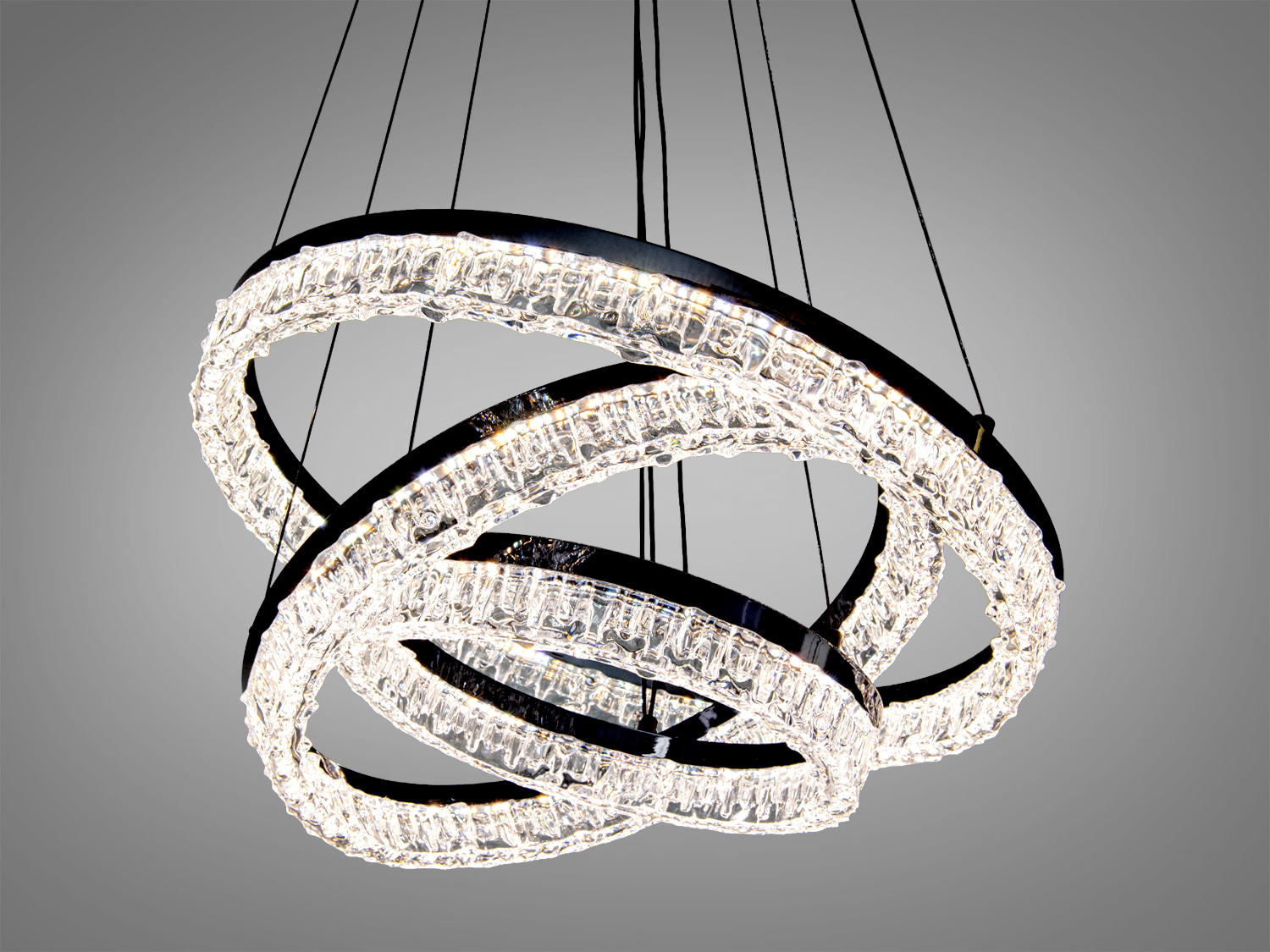 Люстра з трьома кришталевими кільцями, підвішена на тонких дротах, забезпечує рівномірне освітлення. Підходить для просторих кімнат.