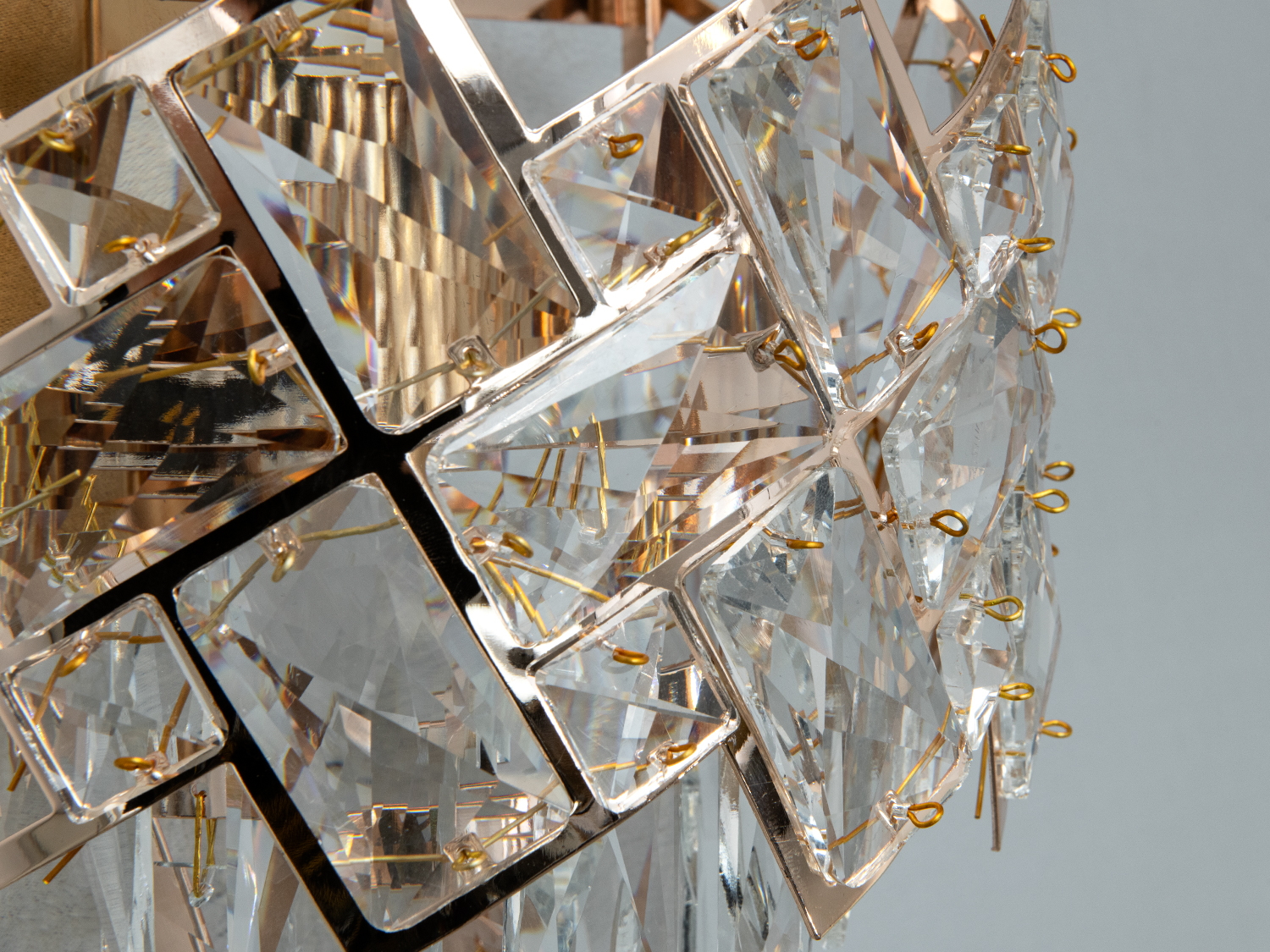 Крупний план кришталевих елементів світильника з металевими деталями. Стильний акцент для будь-якого інтер′єру.