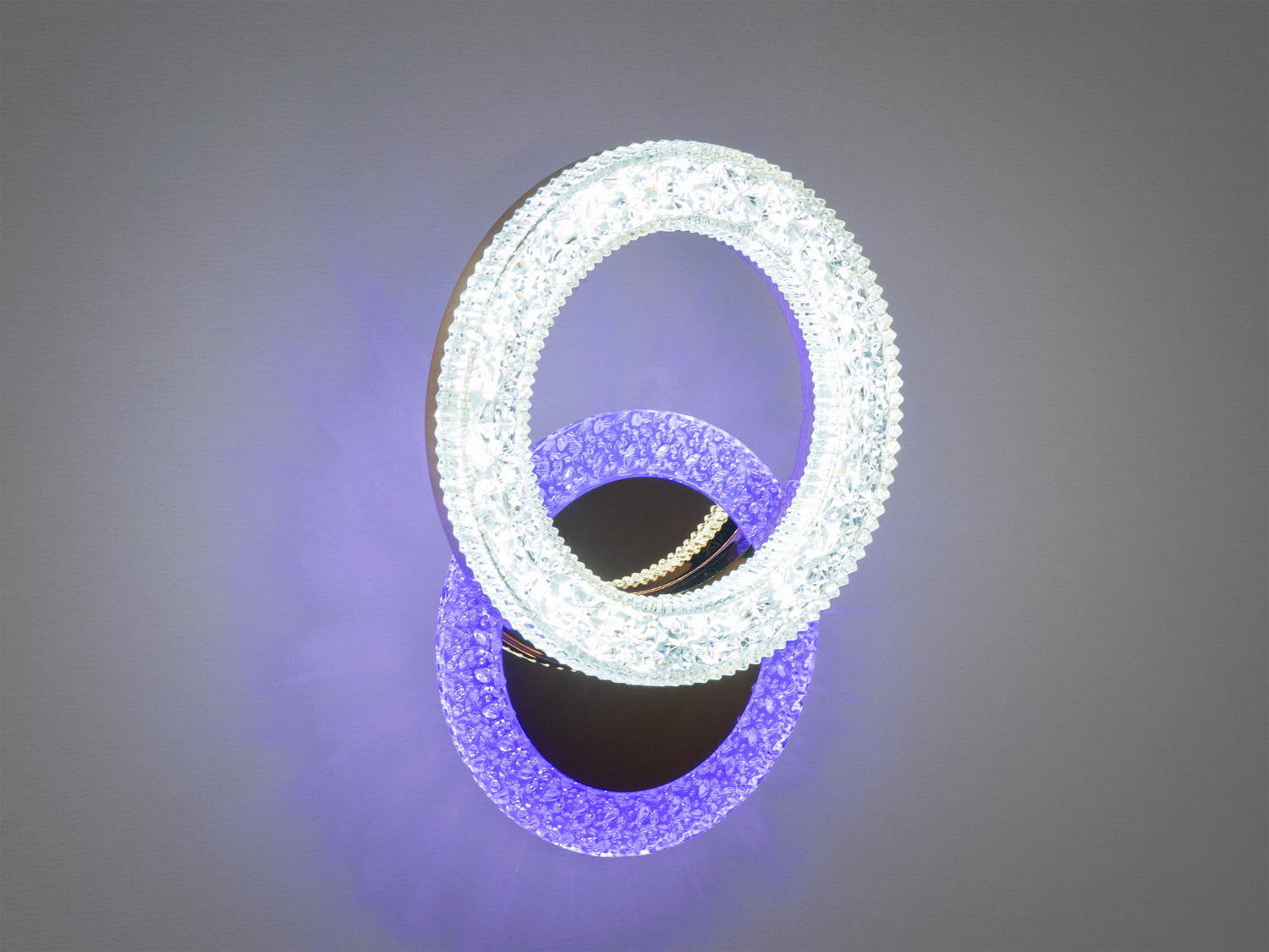 Настінний світильник у формі двох кілець з прозорим дизайном, підходить для будь-якого інтер′єру, забезпечуючи м′яке розсіяне освітлення.