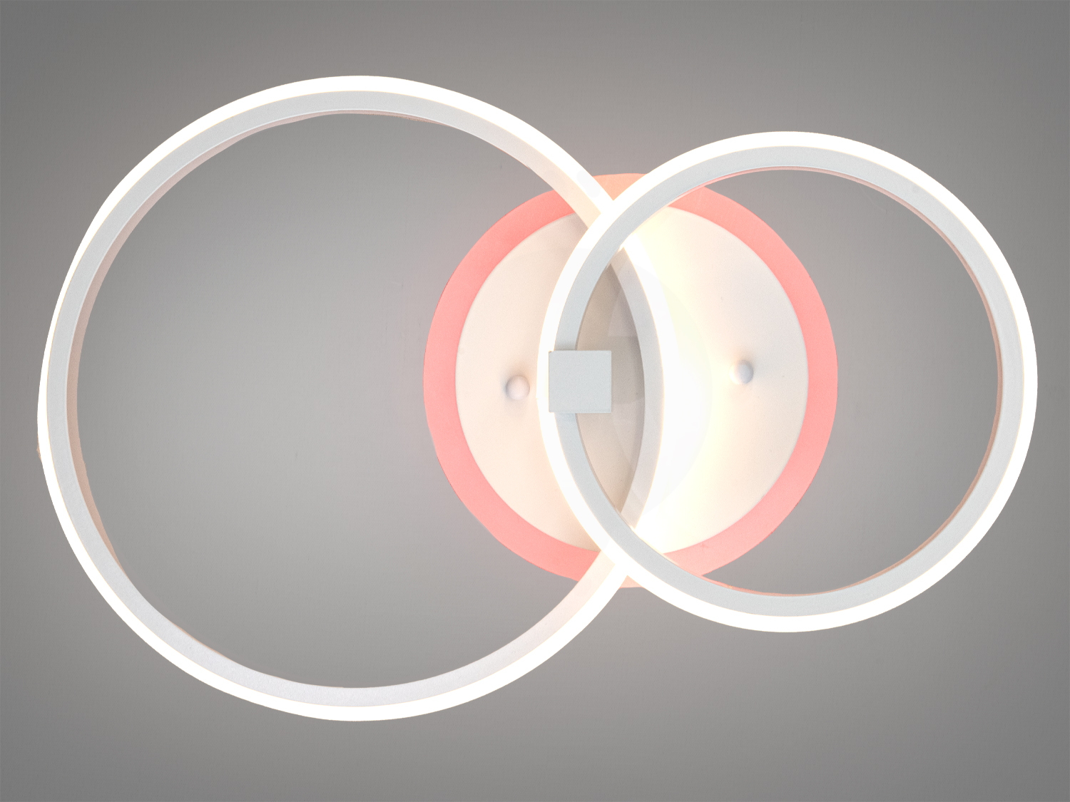 Стельовий світильник з двома кільцями, що випромінюють біле світло з рожевим відтінком, підходить для монтажу в житлових приміщеннях.