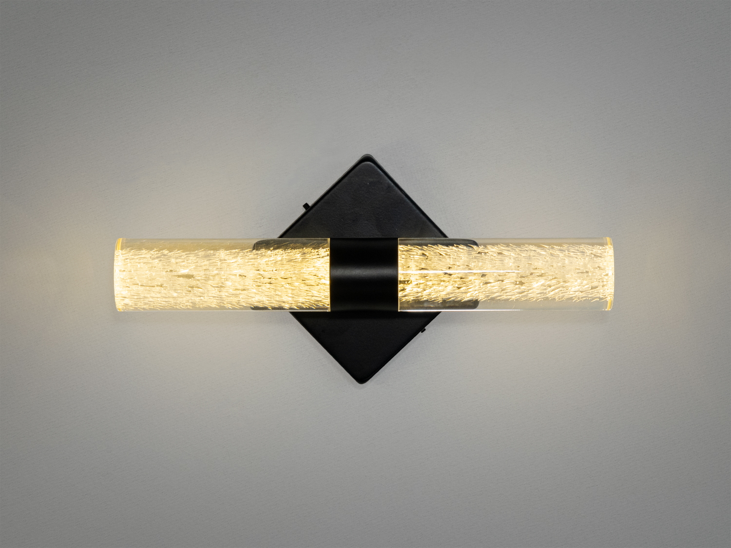 Горизонтальний настінний світильник з квадратною основою, виконаний зі скла з текстурою, що підкреслює стильний дизайн. Підходить для освітлення коридорів.