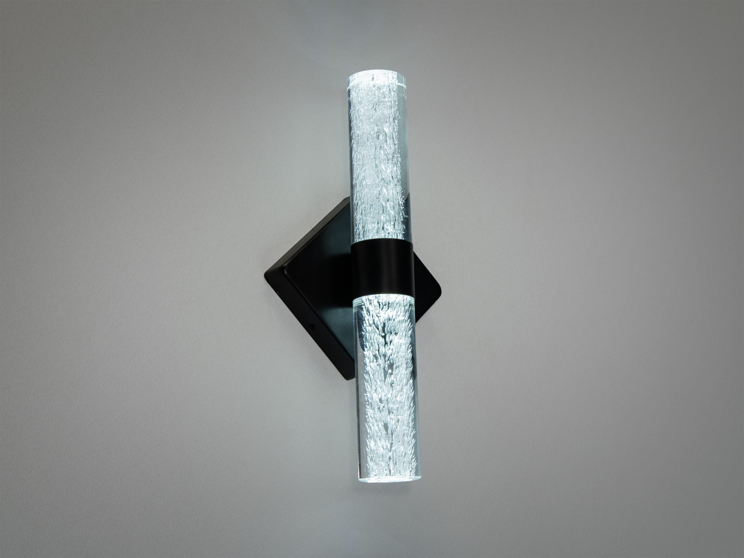 Настінний світильник з діагональним монтажем, виготовлений зі скла з мерехтливим ефектом. Чудово підходить для зонального освітлення вітальні.