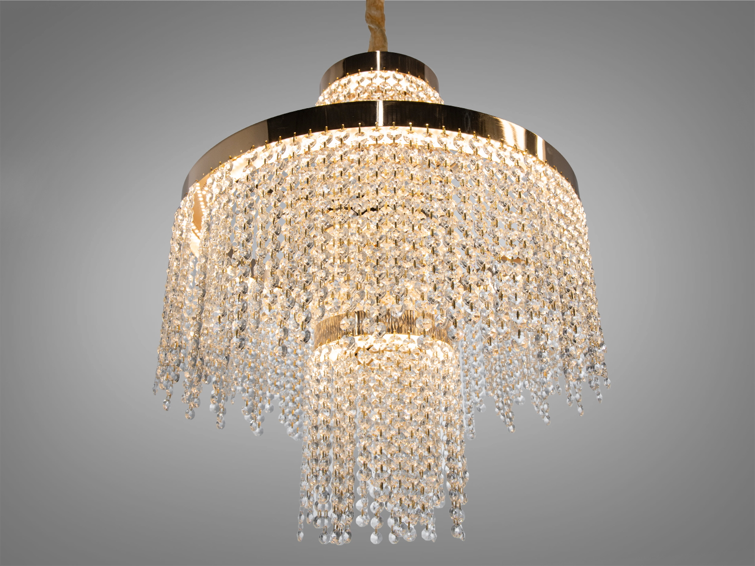 Люстра з блискучими кришталевими підвісками на золотистій основі. Підходить для розкішного оформлення інтер′єру.