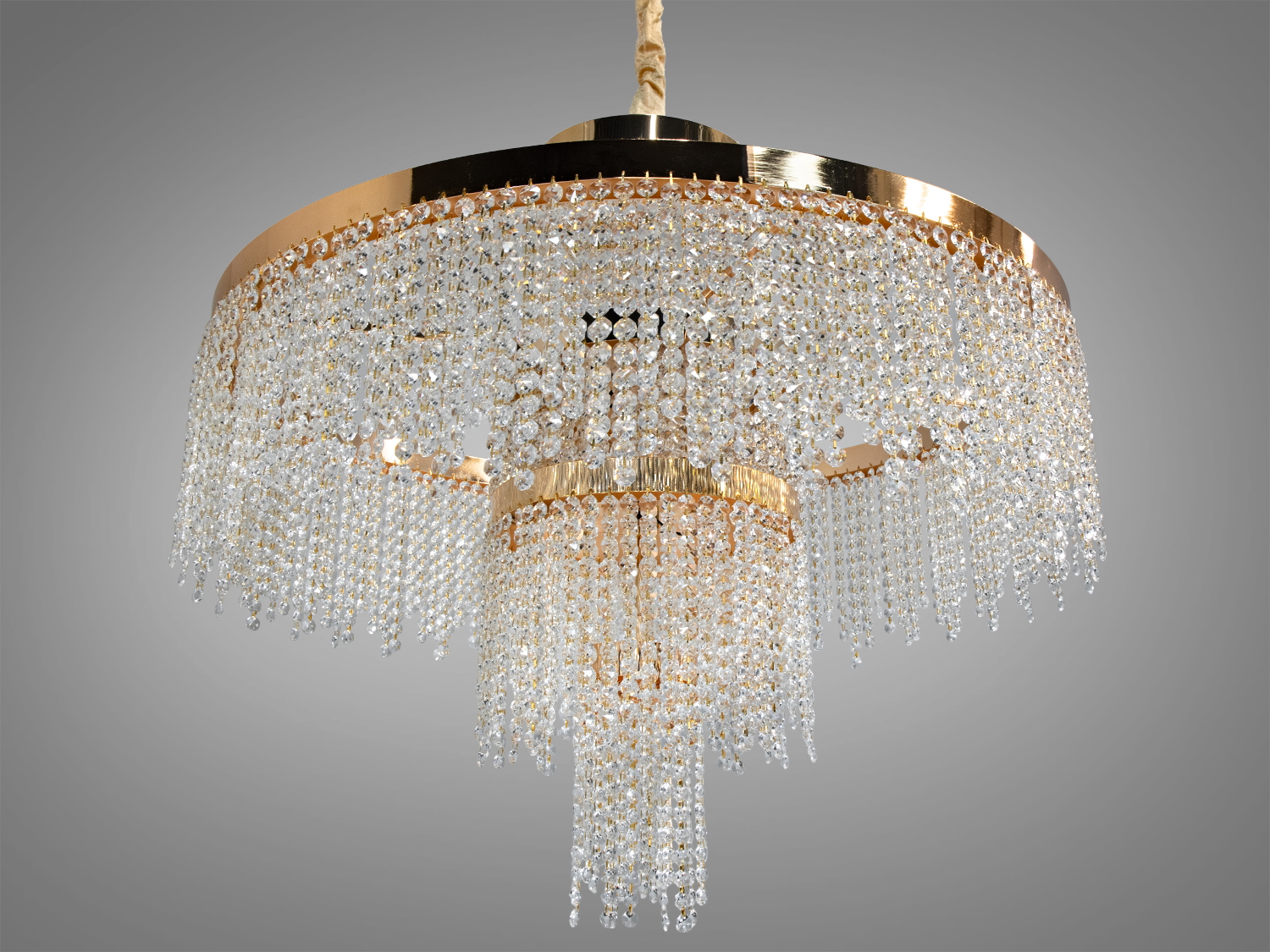 Багатоярусна люстра з кришталевими підвісками, підходить для високих стель. Золотистий обідок надає розкішного вигляду.