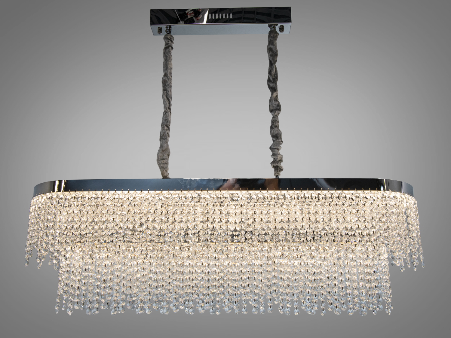 Прямокутна люстра з кришталевими підвісками, що створюють каскадний ефект. Підходить для сучасного інтер′єру з високими стелями.