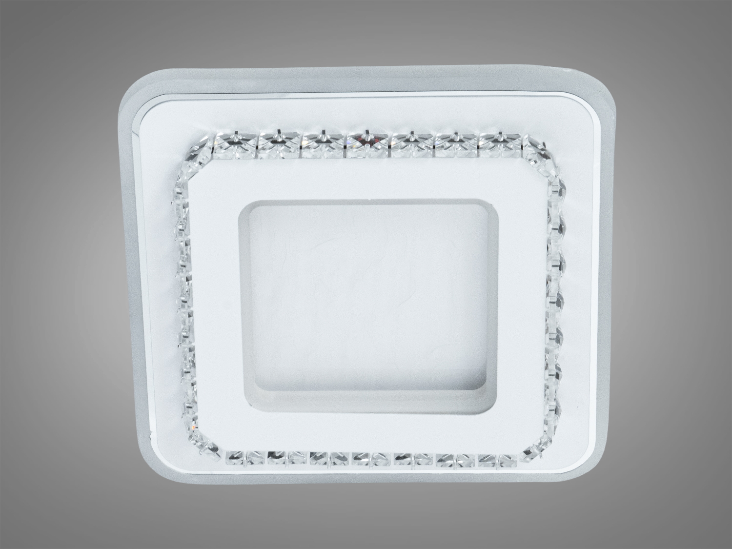 Квадратний світильник для стельового монтажу, виготовлений з прозорого матеріалу. Має декоративну окантовку, підходить для сучасних інтер′єрів.