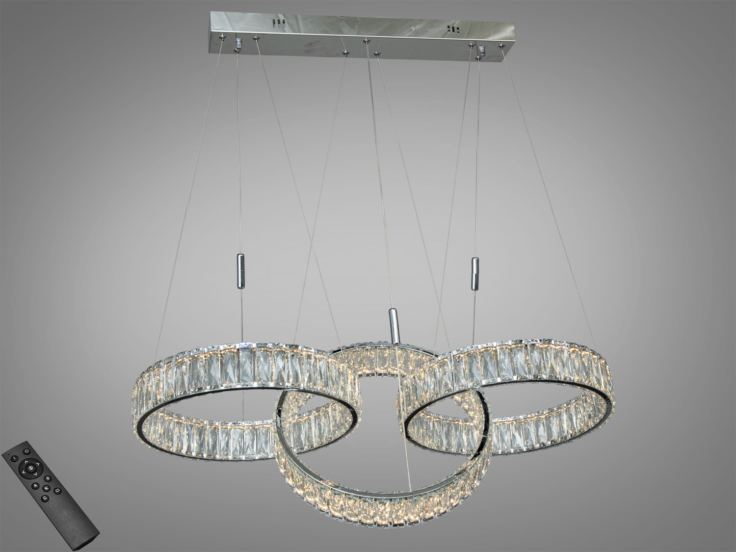 Підвісна люстра з трьома кільцями, оснащена дистанційним керуванням. Прозорі кристали створюють ефектний світловий малюнок.