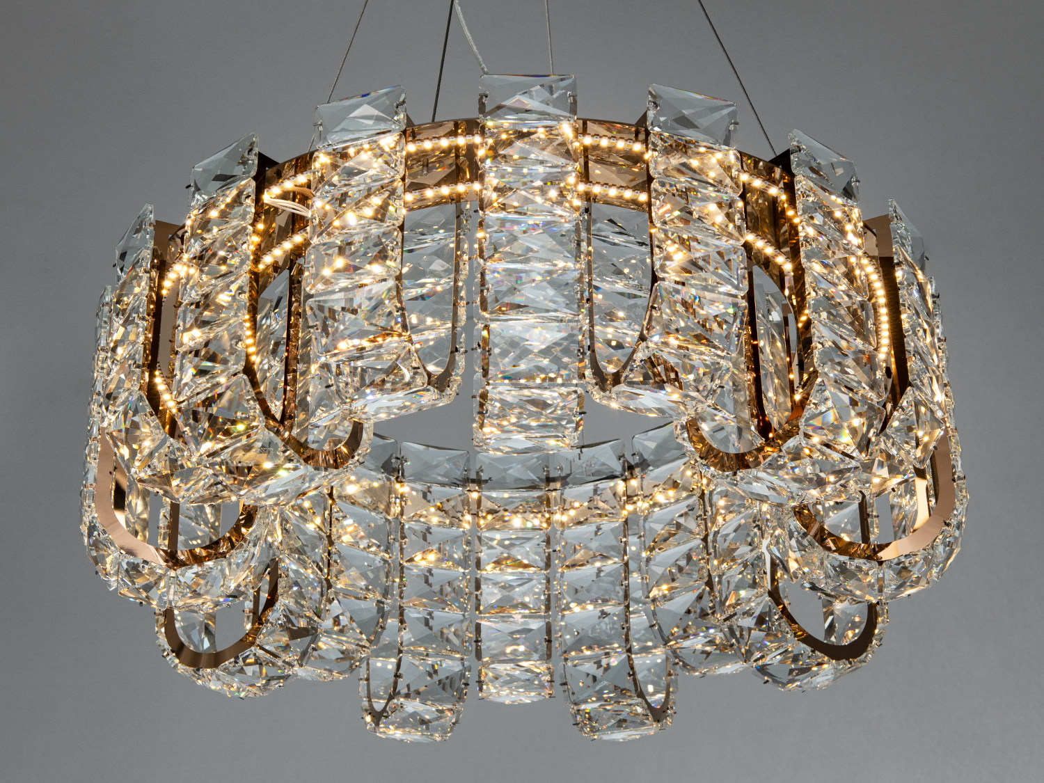 Люстра з кришталевими підвісками, що створюють ефектний світловий малюнок, підходить для вітальні або їдальні.