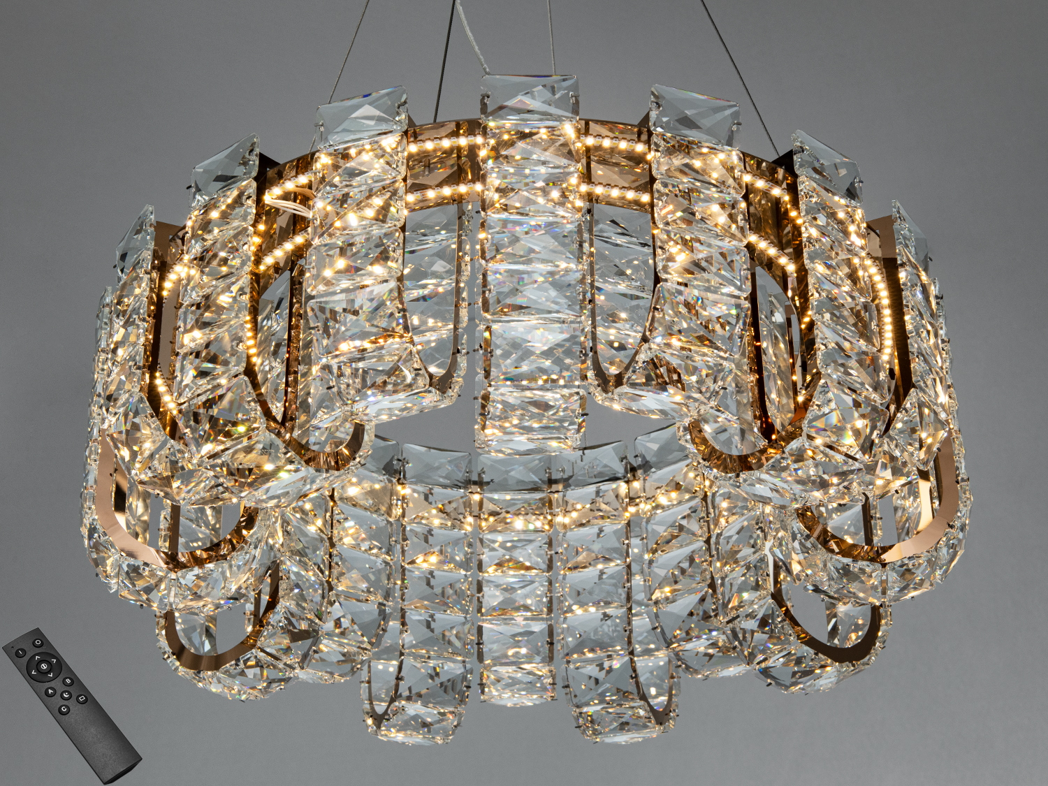Кругла люстра з кришталевими елементами, оснащена пультом дистанційного керування для зручного регулювання яскравості.