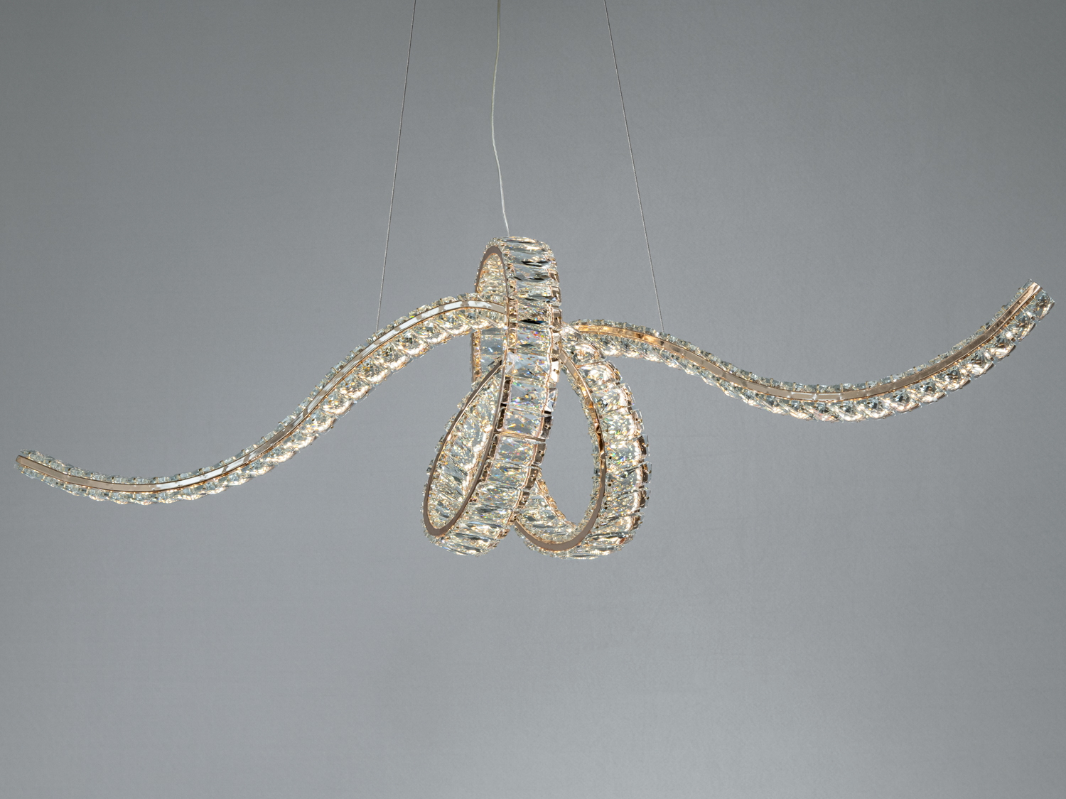 Підвісний світильник із вигнутими лініями, що створюють об′ємну форму. Прозорі елементи додають блиску, ідеально підходить для сучасного інтер′єру.