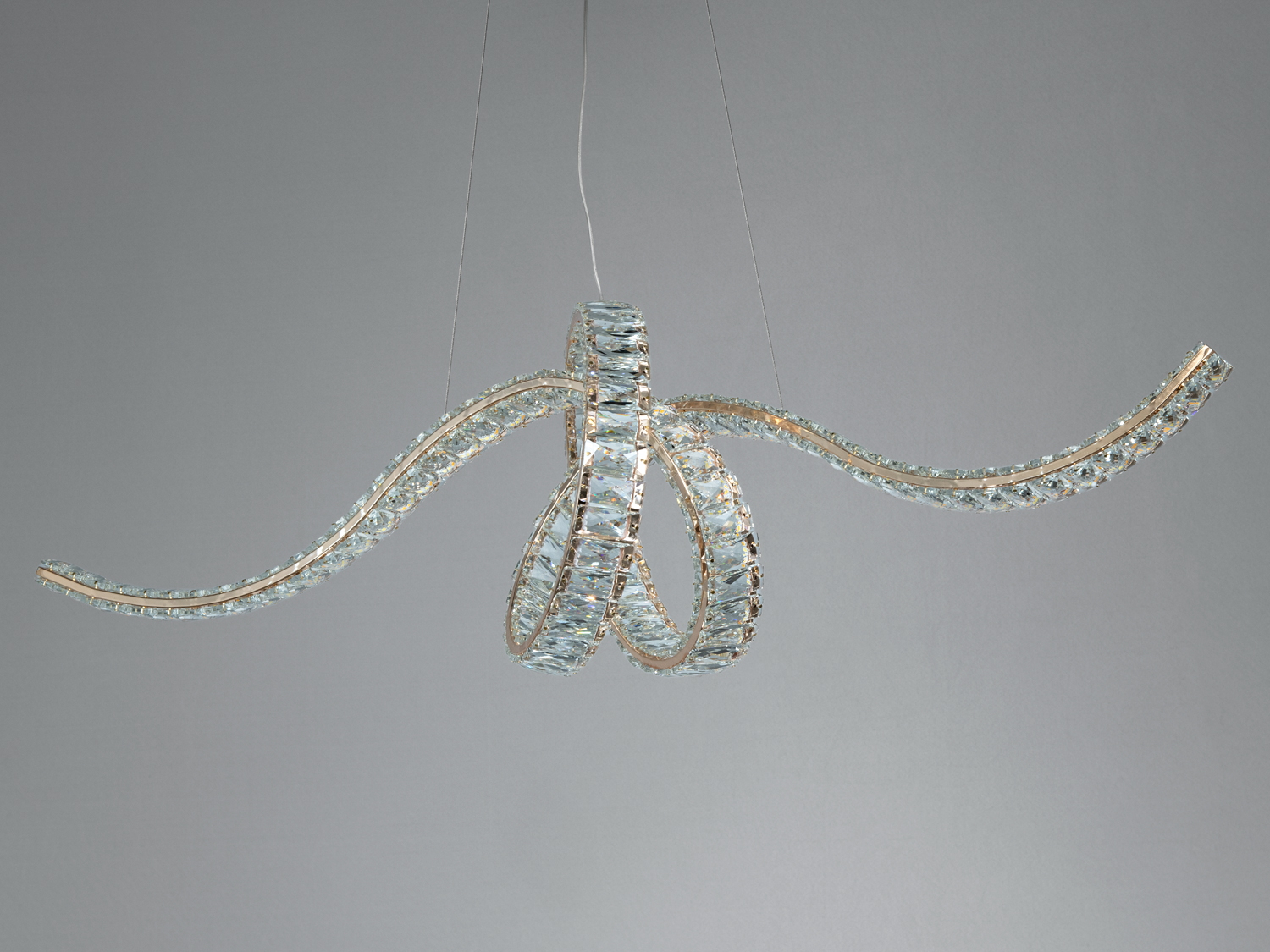 Люстра з хвилястими елементами, що надають легкості конструкції. Скляні вставки підкреслюють стиль, підходить для просторих приміщень.
