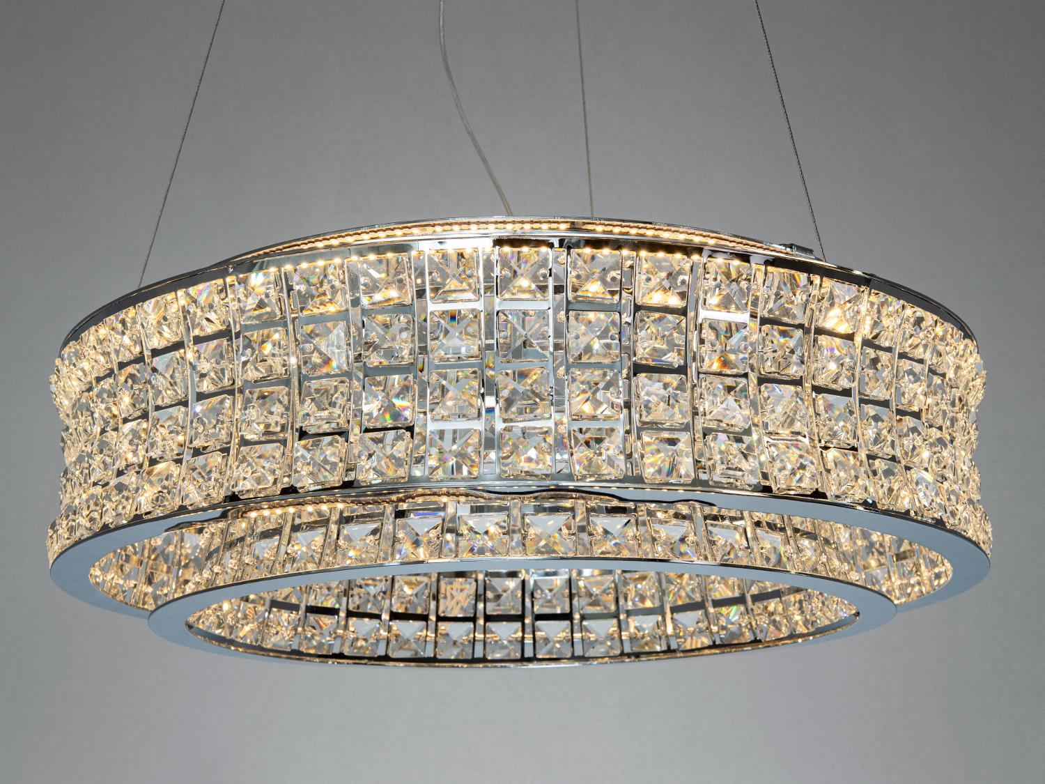 Велика кругла люстра з кристалами, що випромінює тепле світло. Ідеальна для просторих приміщень.