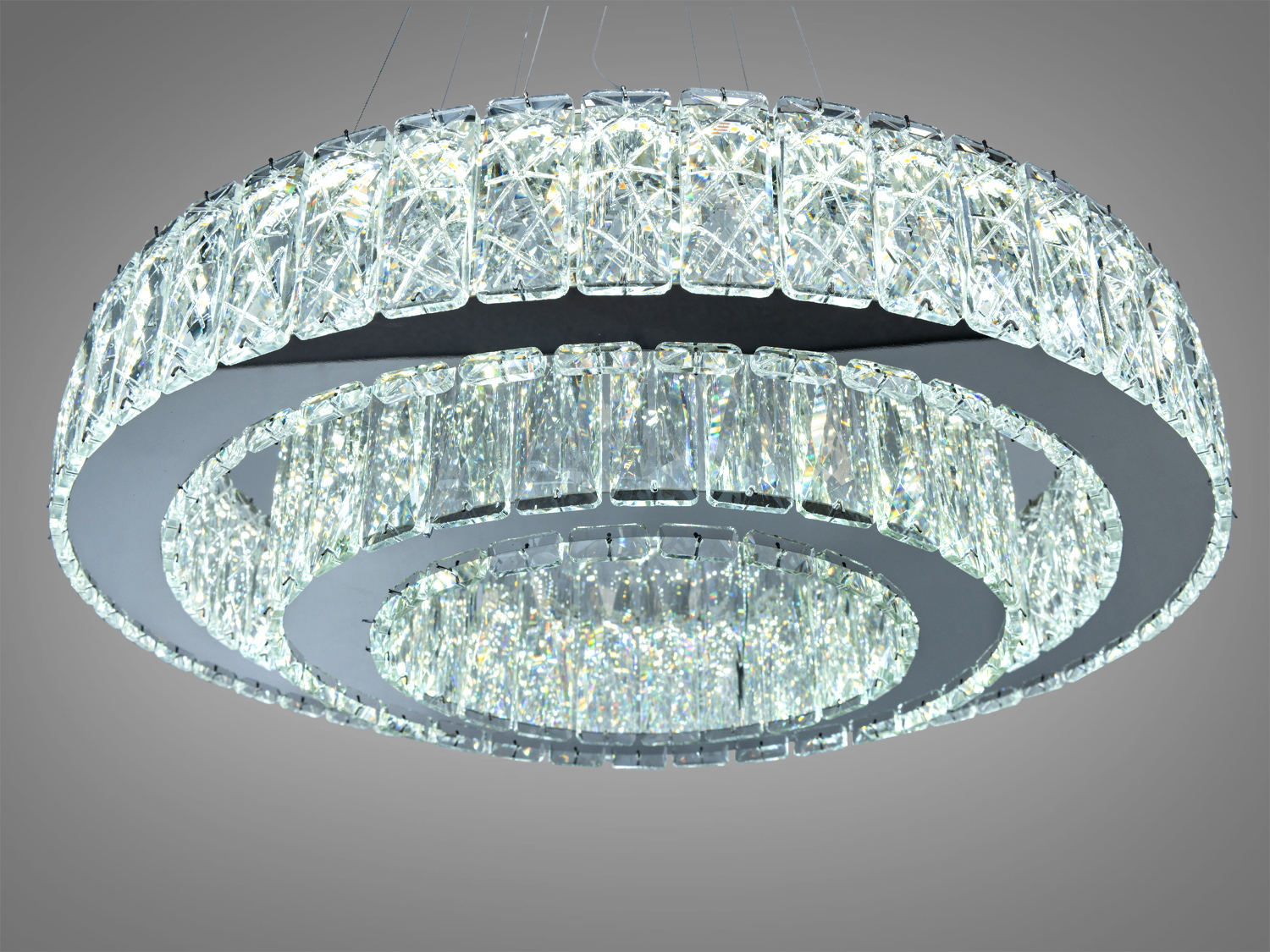 Люстра з двома концентричними кільцями, прикрашена кришталем. Створює ефектний світловий акцент у кімнаті.