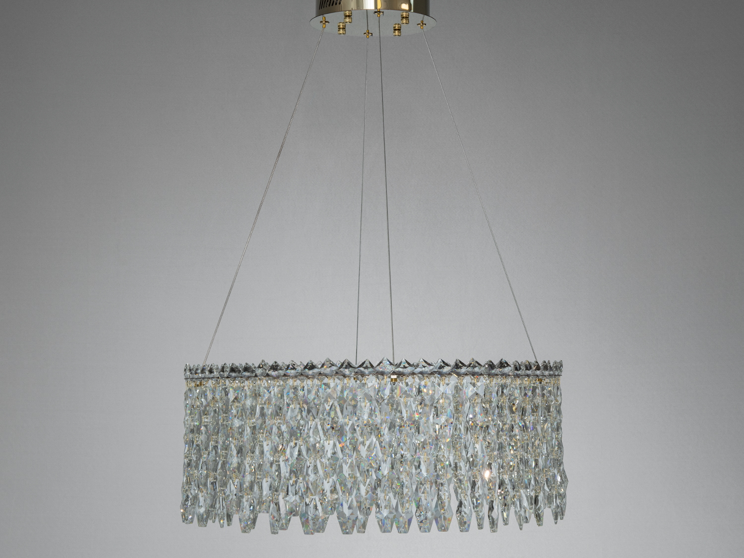 Елегантна люстра з кришталевими підвісами, що підвішена на металевому кріпленні, підходить для класичного інтер′єру.