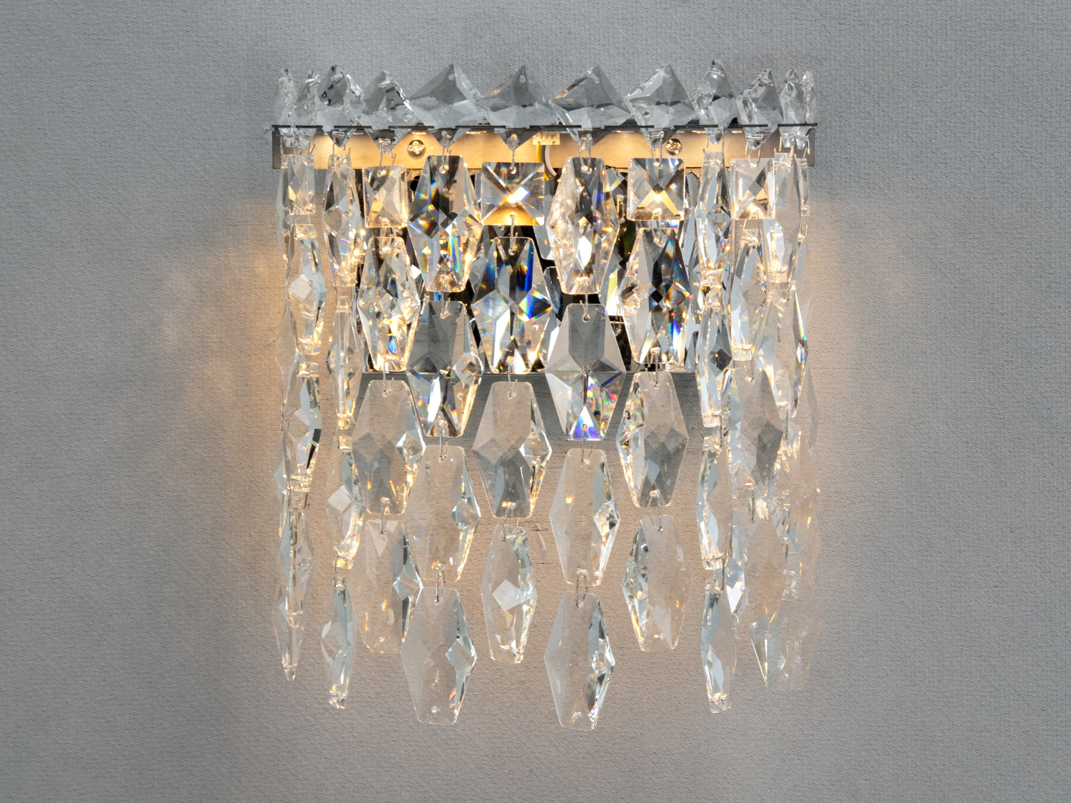 Настінний світильник з кришталевими підвісками, що створює грайливі світлові відблиски. Підходить для спальні, забезпечує затишну атмосферу.