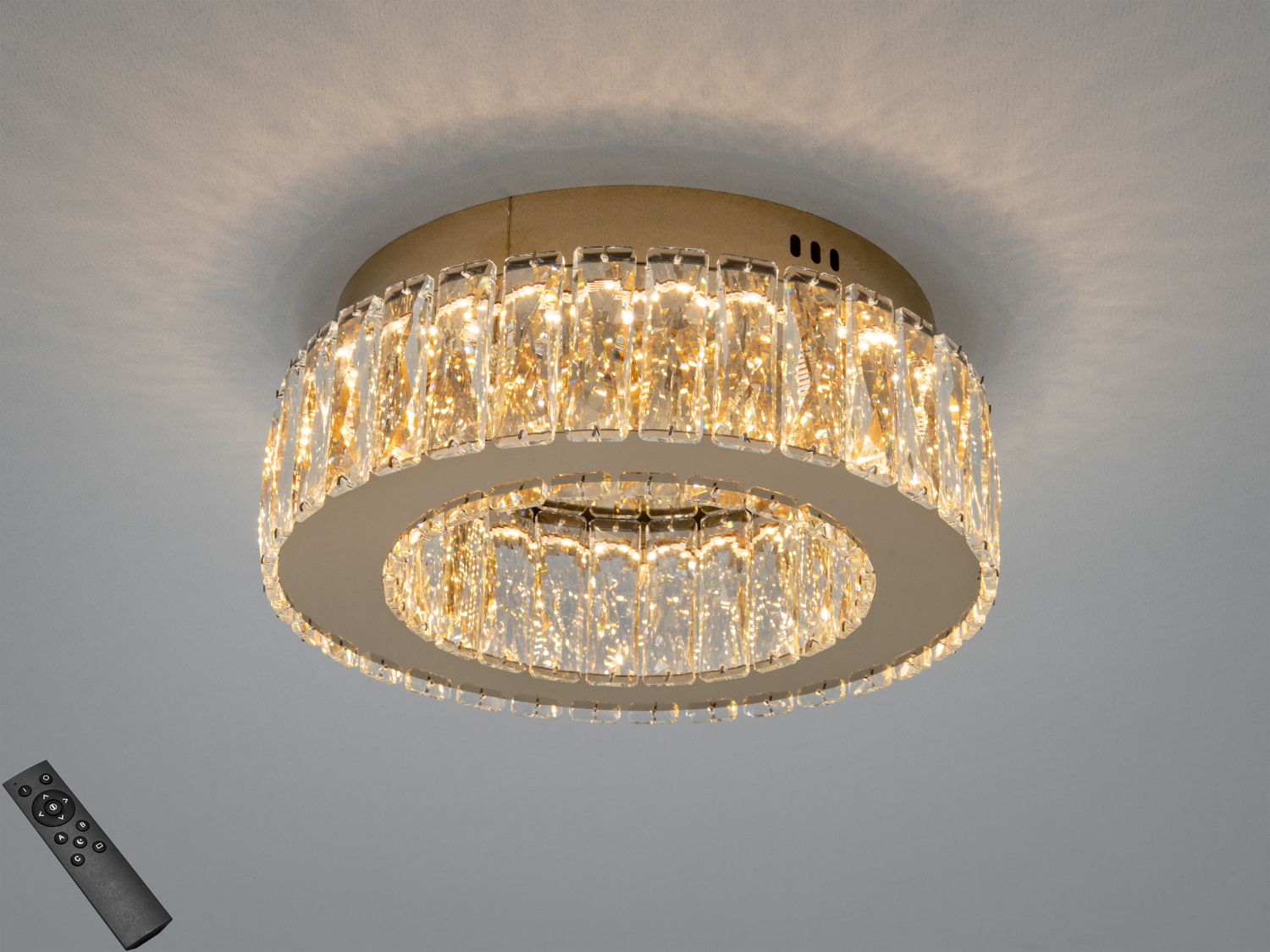 Кругла стельова люстра з кришталевими елементами, оснащена дистанційним управлінням. Підходить для сучасного інтер′єру.
