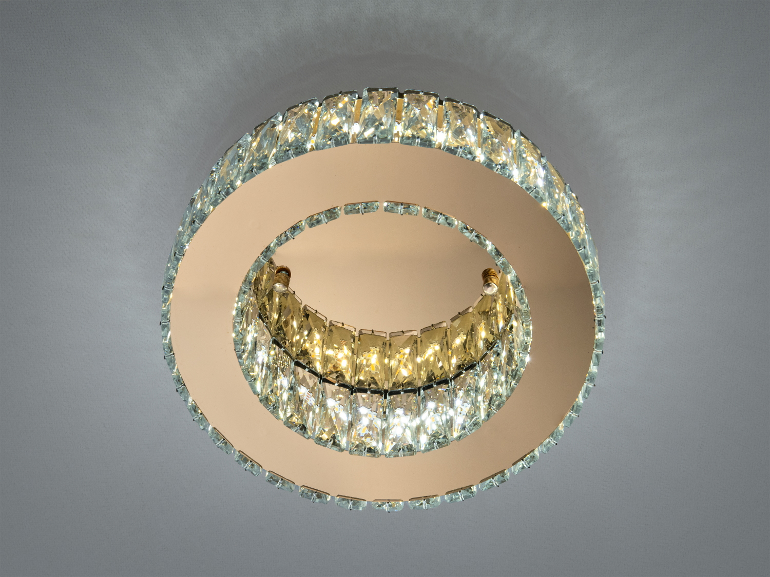 Стельова люстра з двома кільцями кришталевих елементів, які відбивають світло. Ідеальна для вітальні.