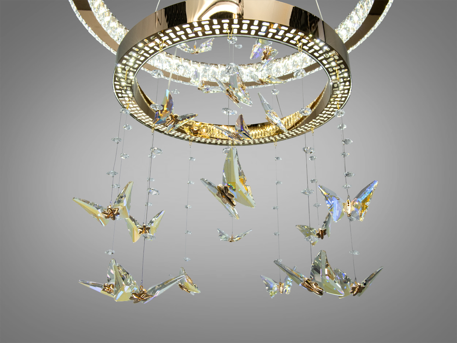 Детальний вид на нижню частину люстри з кришталевими метеликами, що підвішені на прозорих нитках для елегантного вигляду.