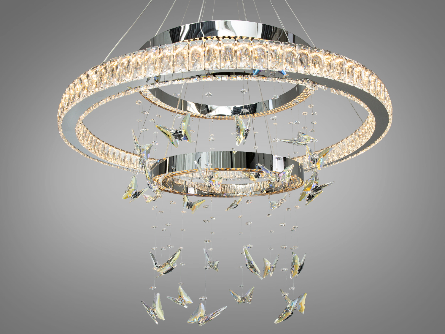 Вишукана підвісна люстра з кришталевими підвісками, що імітують метеликів, має тепле світло, підходить для вітальні.