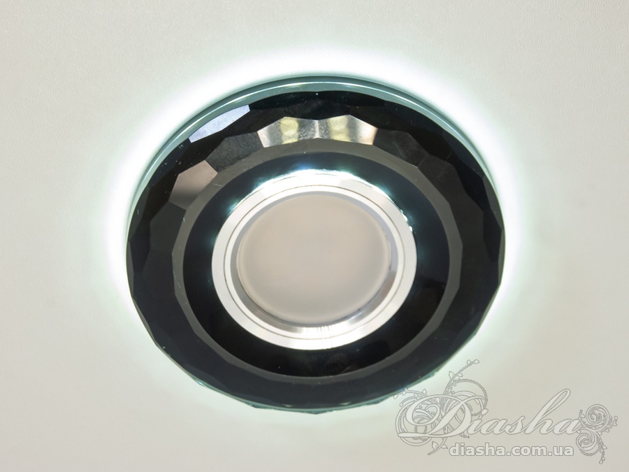 Круглий точковий світильник з LED підсвічуванням, дизайн якого відрізняється вишуканістю та сучасністю. Він стане не тільки джерелом світла, а й елементом декору для будь-якого інтер'єру, в якому буде використовуватись.
Зовнішня, декоративна частина світильника привертає увагу своїм оригінальним дизайном. Вона виконана у формі круглого диска зі скла, поверхня якого прикрашена множинними округлими вирізами, що створюють грайливий візерунок. Кожен такий виріз утворює невелику лінзу, через яку проходить світло, створюючи цікаву гру світла і тіні на поверхні стелі. Матеріал диска має високий ступінь відблиску, що додатково посилює світловий ефект і робить світильник помітним елементом декору.
Функціональна, вбудована частина світильника забезпечує його основну роль – освітлення. Вона містить каркас, який вміщує в собі джерело світла та затискачі для кріплення до стелі. Така конструкція дозволяє легко монтувати світильник в підвісні стелі, ніші або над робочою поверхнею, забезпечуючи при цьому надійне кріплення.
LED підсвічування, вбудоване в світильник, має потужність 3 Вт і нейтральну білу колірну температуру 6400K, що забезпечує якісне та комфортне для очей світло. Це робить світильник ідеальним для використання в різних приміщеннях будинку, включаючи вітальні, спальні, кухні та коридори. Крім того, завдяки своїй вологостійкості, він підходить навіть для установки у ванних кімнатах.
Сучасні точкові світильники розроблені таким чином, щоб забезпечувати рівномірне освітлення всього приміщення, одночасно даючи можливість акцентувати на певних деталях інтер'єру. Така універсальність робить їх затребуваними серед споживачів, які цінують як функціональність, так і естетику в дизайні свого житла.
Для оптових покупців відпускається лише ящиками по 50 шт.
Лампа MR-16 в комплект не входять.