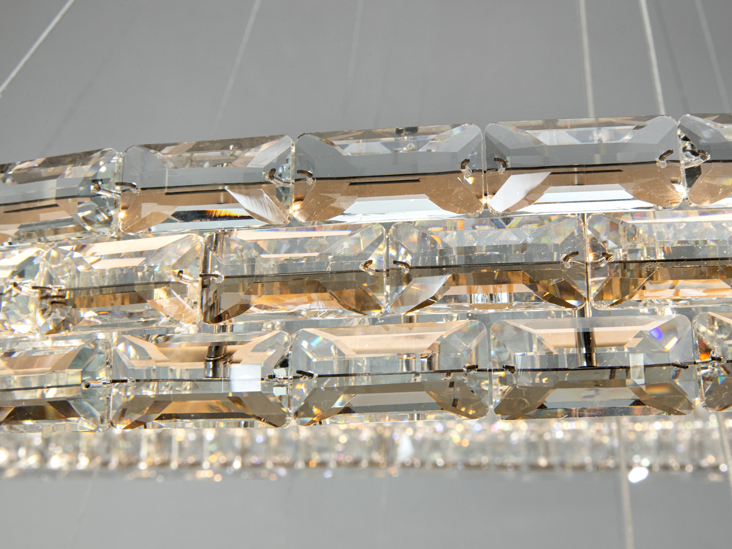 Близький план кристалів на люстрі, що підкреслює їхню прозорість і здатність відбивати світло.