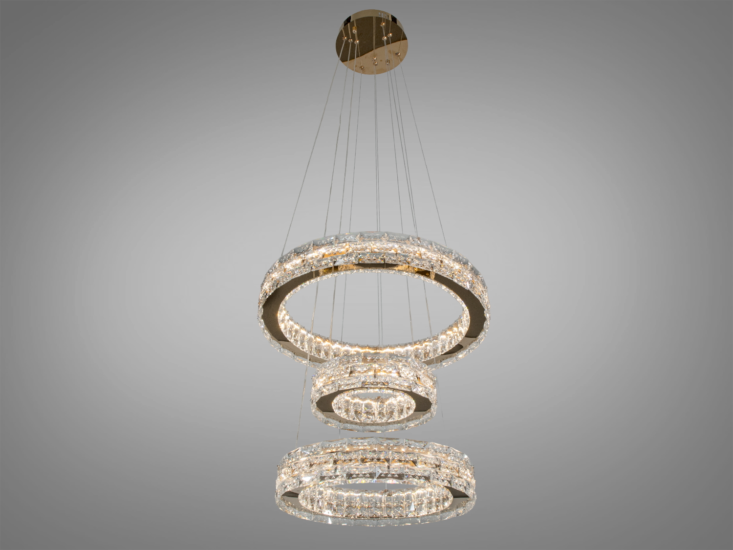 Люстра з трьома кільцями, виготовлена з металу та кришталю. Підходить для монтажу в залах, створює вишукану атмосферу.