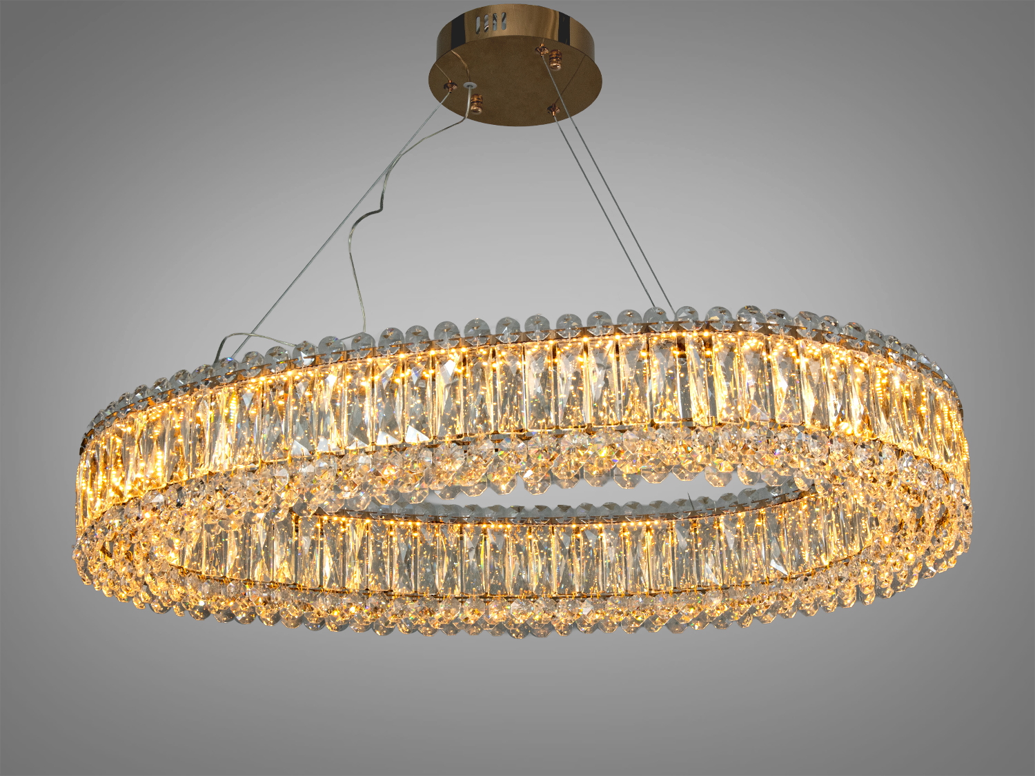 Овальна люстра з кришталю, підвішена на тросах, випромінює тепле світло, ідеальна для вітальні.