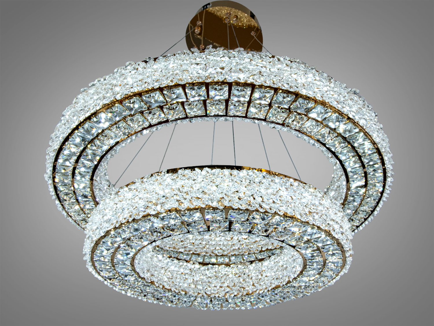 Дворівнева люстра з прозорими кристалами, підвішена на тонких тросах. Ідеально підходить для великих приміщень.