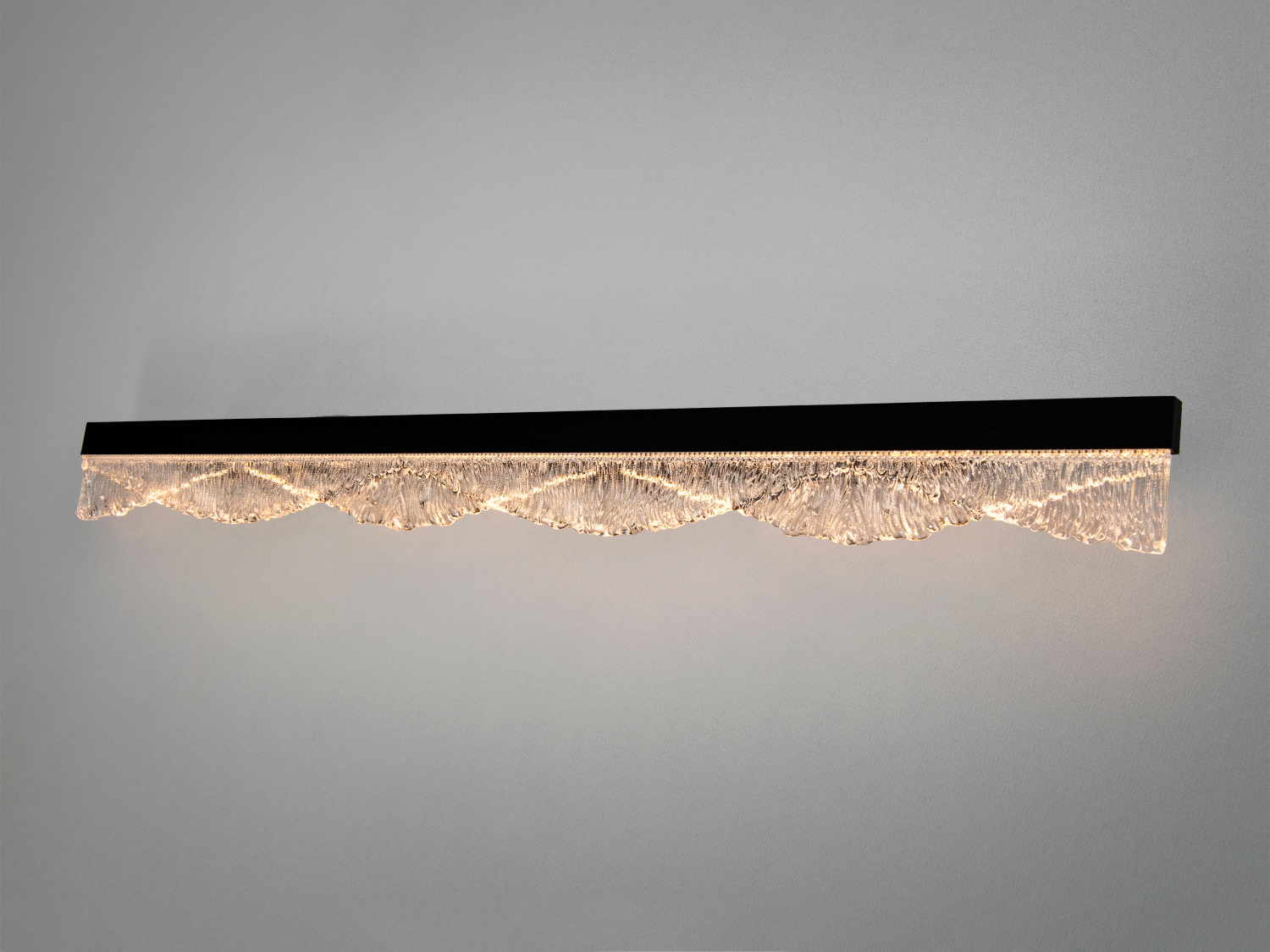 Настінний світильник з хвилястим акриловим елементом, що підсвічується зсередини. Ідеальний для освітлення коридорів або віталень.