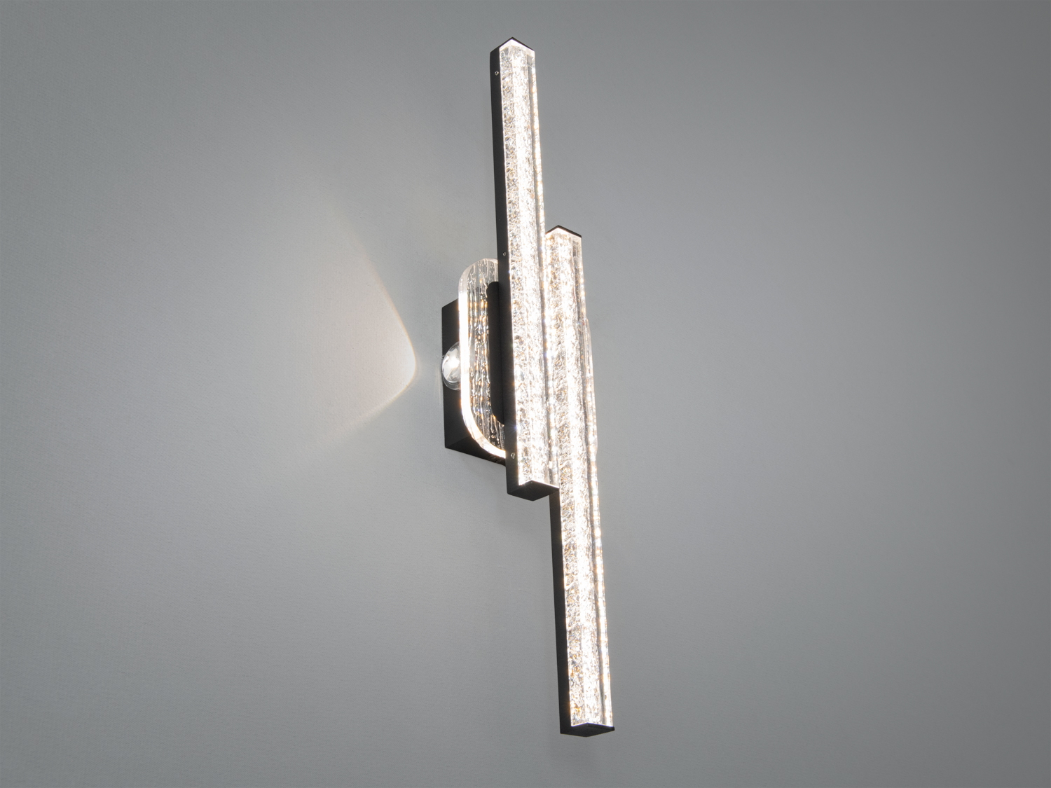 Вертикальний настінний світильник з двома LED-смугами, закріплений на овальній основі, створює м′яке освітлення.