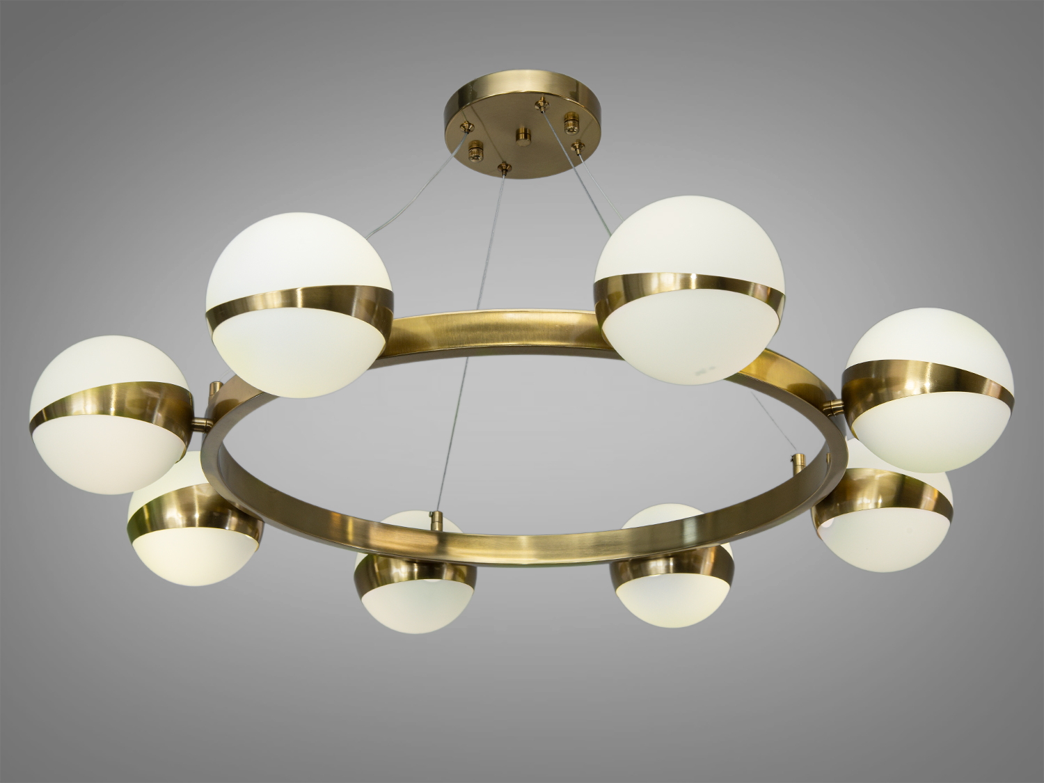 Люстра з круглими плафонами, підвішена на кабелях, з металевими елементами бронзового кольору, підходить для сучасного інтер′єру.
