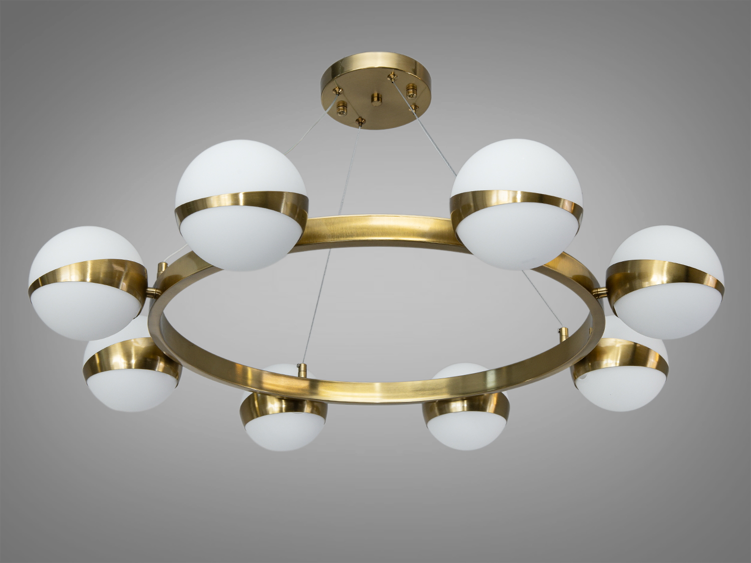 Підвісна люстра з білими кулястими плафонами, що кріпляться на металевому кільці, ідеальна для вітальні або їдальні.