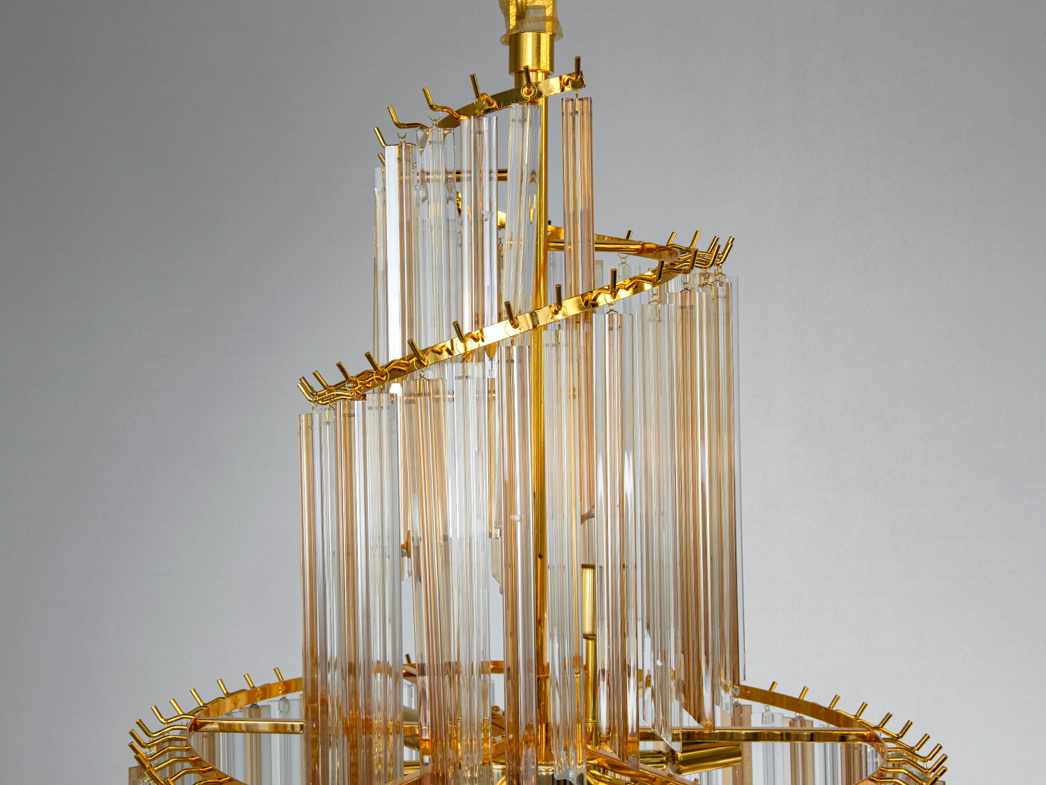 Верхня частина люстри з золотистими металевими деталями, що підкреслюють сучасний стиль освітлення.