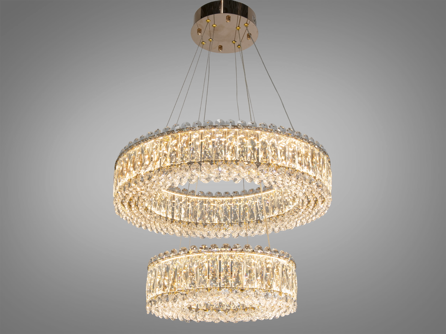 Підвісна люстра з двома кільцями, прикрашеними кришталевими підвісками, створює елегантне освітлення для вітальні.