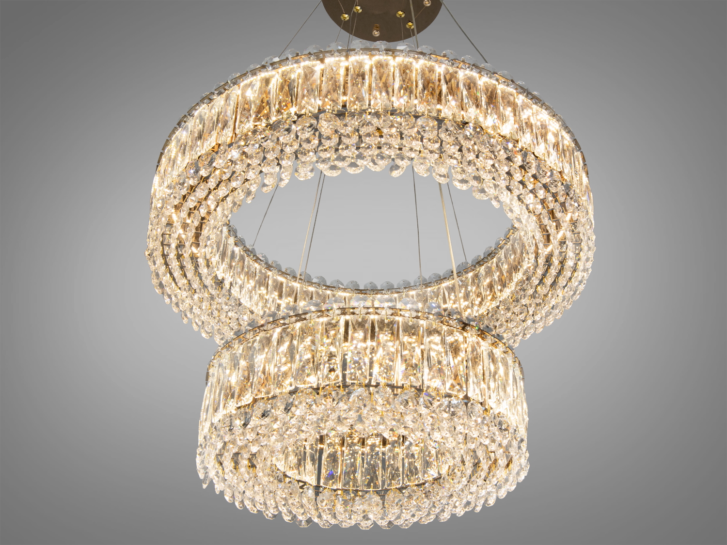 Кришталеві підвіски на люстрі утворюють каскадний ефект, підкреслюючи сучасний дизайн освітлення.