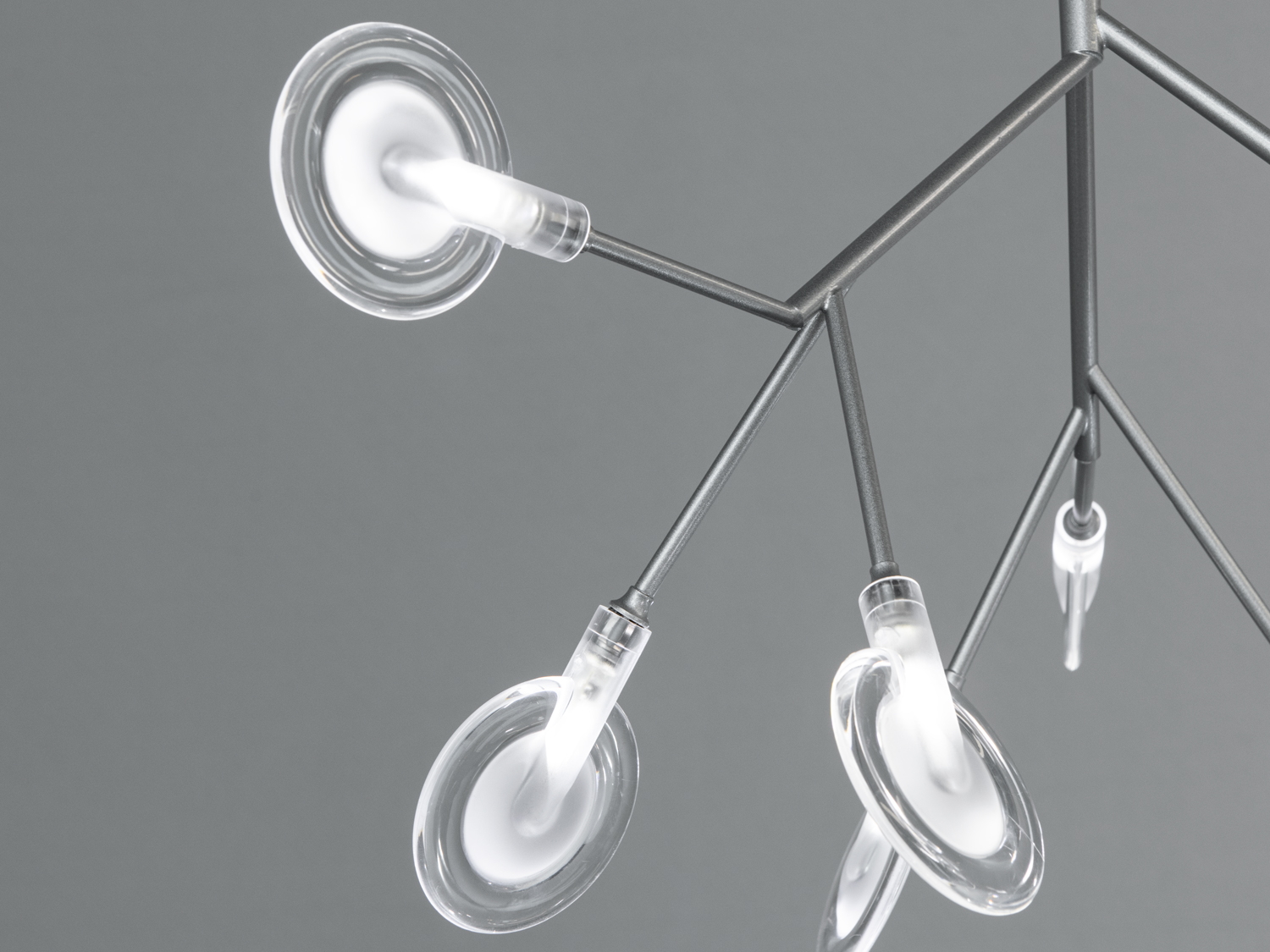 Деталь підвісного світильника з фокусом на скляні плафони, що забезпечують розсіяне освітлення, ідеально підходять для вітальні.