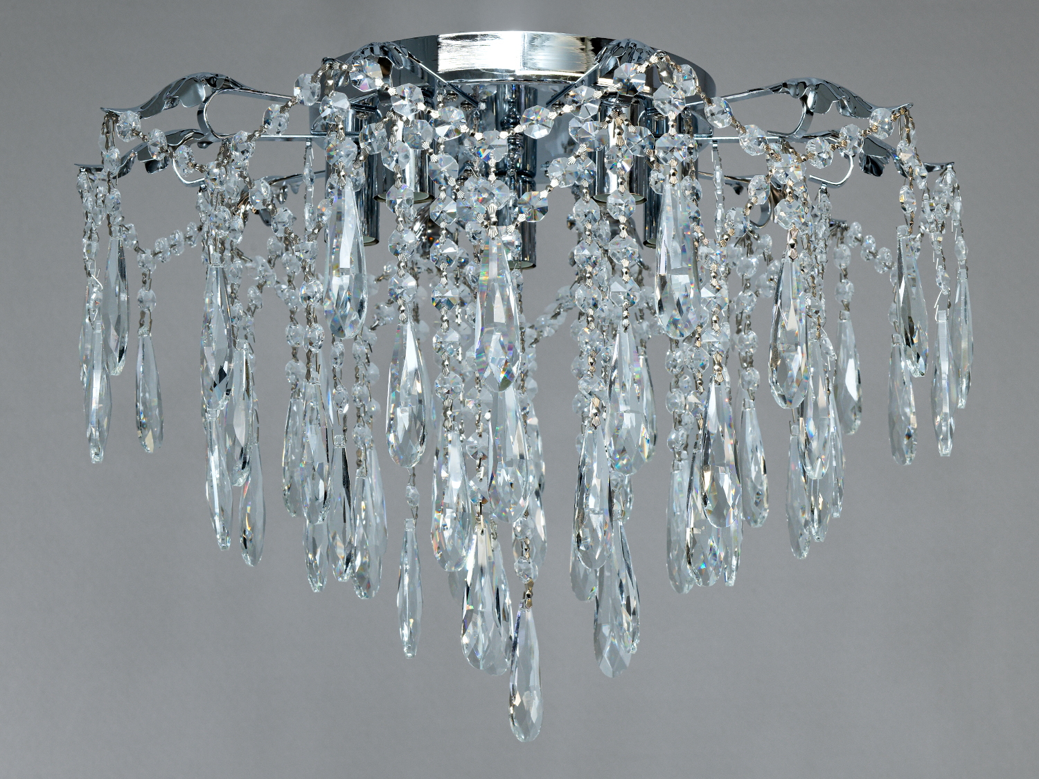 Стельова кришталева люстра у хромі з 5 патронами E14. Підходить для кімнат до 10 м², металевий каркас, кришталеві підвіски, монтаж на планку, керування настінним вимикачем.