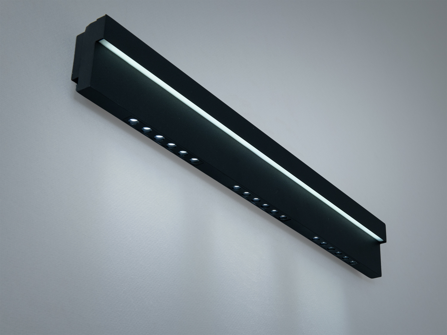 Лінійний світильник з вбудованими світлодіодами, чорний корпус. Призначений для настінного монтажу, забезпечує рівномірне освітлення.
