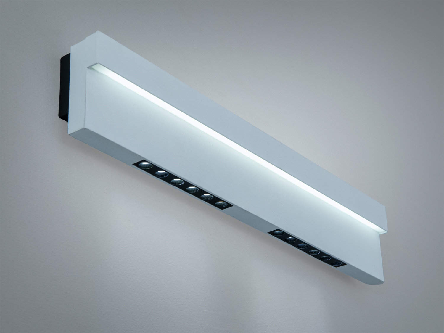 Білий настінний світильник з верхнім світлом, має лінійний дизайн. Ідеально підходить для мінімалістичних просторів.