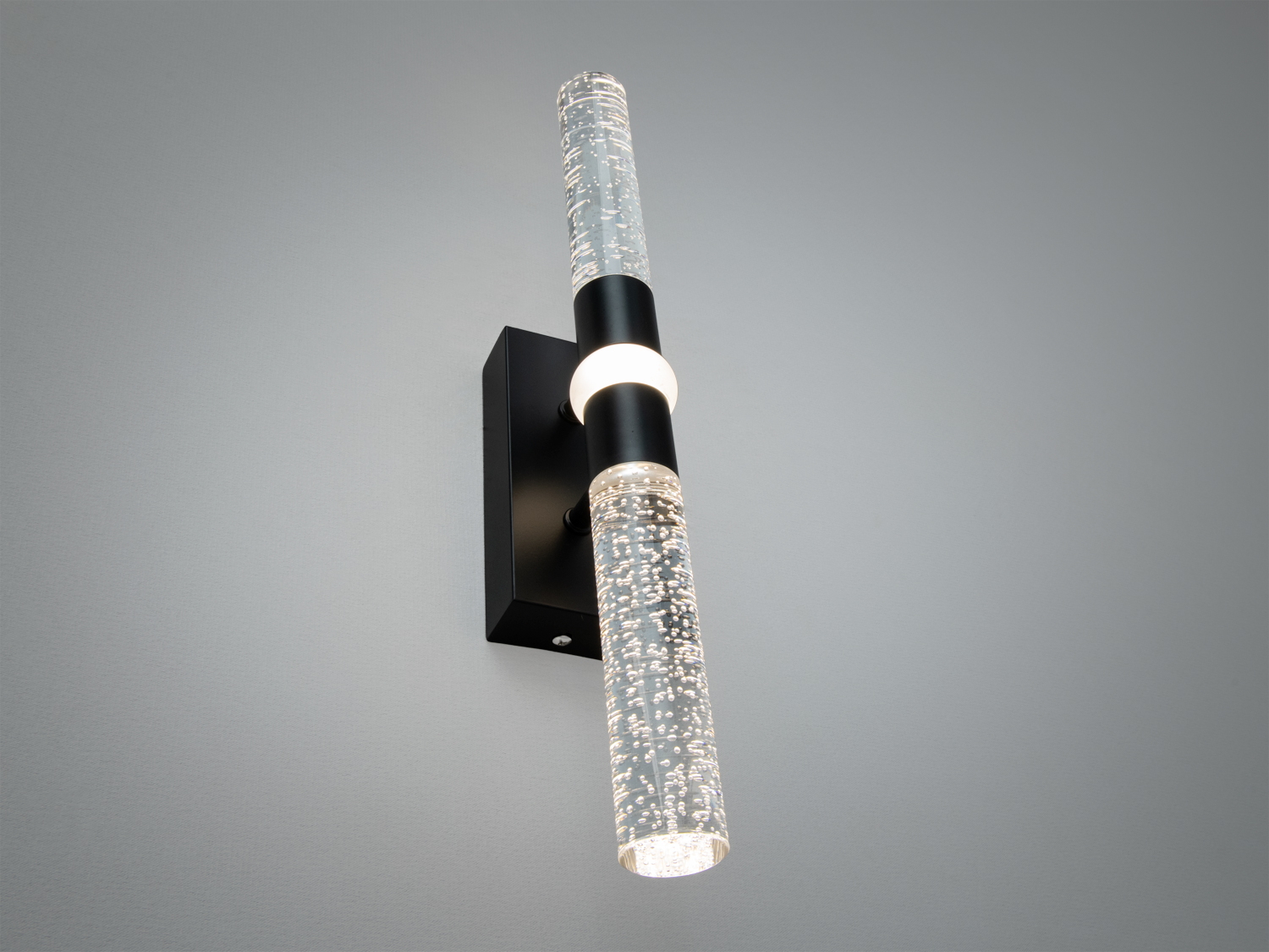 Світильник для стіни з двома трубками, наповненими бульбашками, забезпечує м′яке освітлення. Підходить для сучасних інтер′єрів.